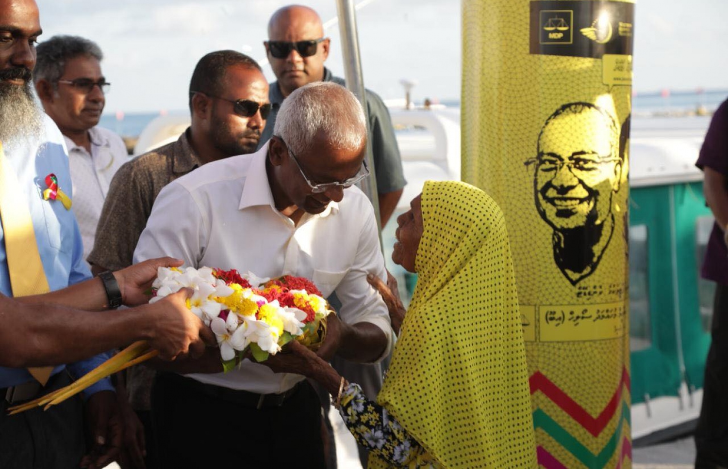 އިބޫ މިއަދު ހިންނަވަރަށް ވަޑައިގެން އިދިކޮޅު ސަޕޯޓަރަކު އޭނާ އަށް މާބޮނޑިއެއް ހަދިޔާ ކުރަނީ. އެތައް ސަތޭކަ ބަޔަކު، އިބޫ އަށް މަރުހަބާ ދަންނަވަން އެއްވި. - ފޮޓޯ: އެމްޑީޕީ