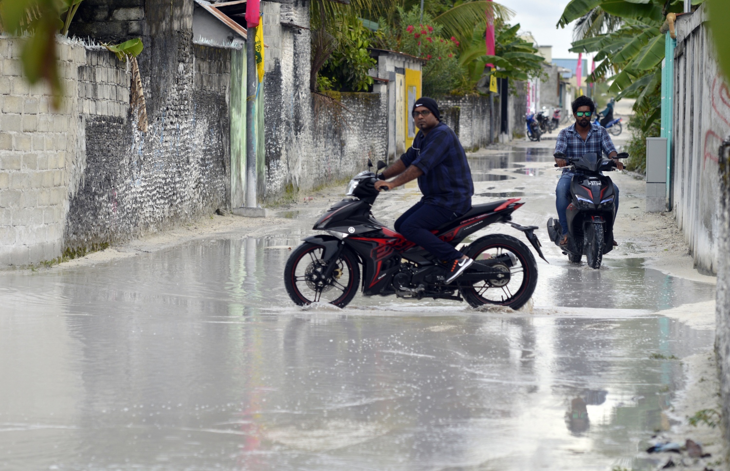 ފެންބޮޑުވެފައިވާ، ހިތަދޫގެ މަގަކުން މީހަކު ސައިކަލްގައި ދަނީ: އައްޑޫގެ ރަށްރަށުގެ މަގުތަކުގެ ހާލަތު އިންތިހާ އަށް ދަށް.