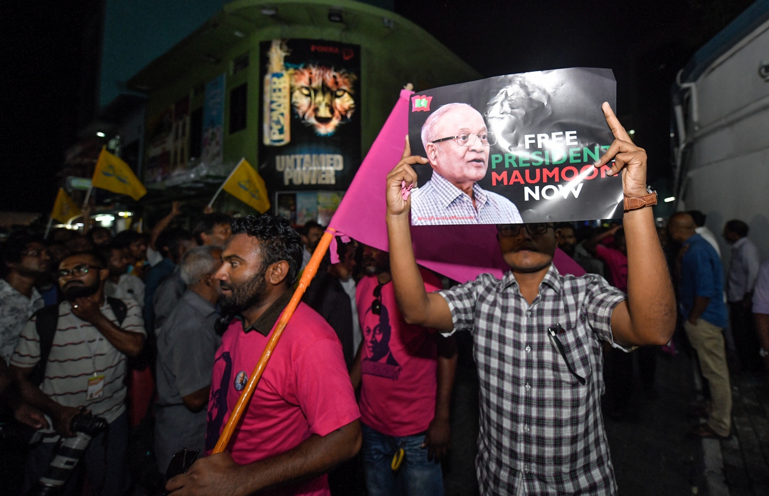 ސެޕްޓެމްބަރު 24، 2018- ކްރިމިނަލް ކޯޓު ސަރަހައްދު: ޝަރީއަތް ނިމެންދެން ބަންދުކޮށްފައި ތިބި ސިޔާސީ ބައެއް ބޭފުޅުން މިނިވަންކުރުމާ ގުޅިގެން ކްރިމިނަލް ކޯޓު ސަރަހައްދައް އެއްވެތިިބި މީހުންގެ ތެރެއިން މީހަކު ކުރީގެ ރައީސް މައުމޫން މިނިވަންކުރުމަށް ގޮވާލާ ޕޯސްޓަރެއް ހިފާއްޓައިގެން.---ފޮޓޯ: ހުސައިން ވަހީދު/މިހާރު