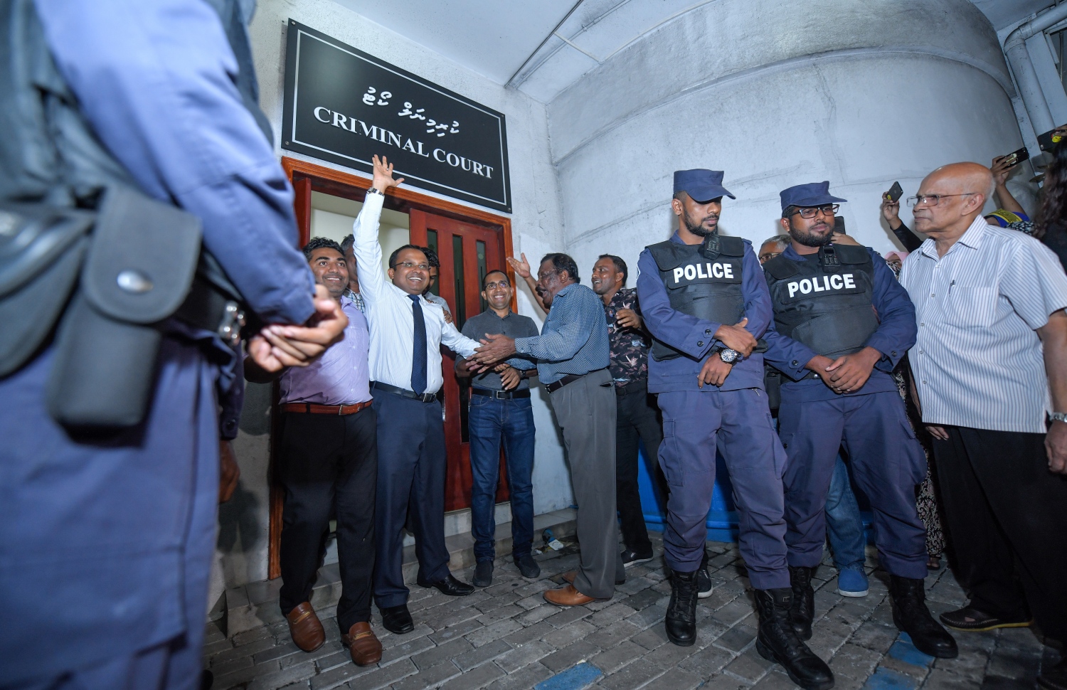 ސެޕްޓެމްބަރު 24، 2018- ކްރިމިނަލް ކޯޓު ސަރަހައްދު: ޝަރީއަތް ނިމެންދެން ބަންދުކޮށްފައި ހުރި ކިނބިދޫ ދާއިރާގެ މެމްބަރު އަބްދުﷲ ރިޔާޒު މިނިވަންވެ ކޯޓުން ނިކުމެވަޑައިގަތުމަށްފަހު އެއްވެ ތިބި މީހުންނަށް އިޝާރާތްކުރައްވާ އުފާފާޅުކުރައްވަނީ.---ފޮޓޯ: ހުސައިން ވަހީދު/މިހާރު