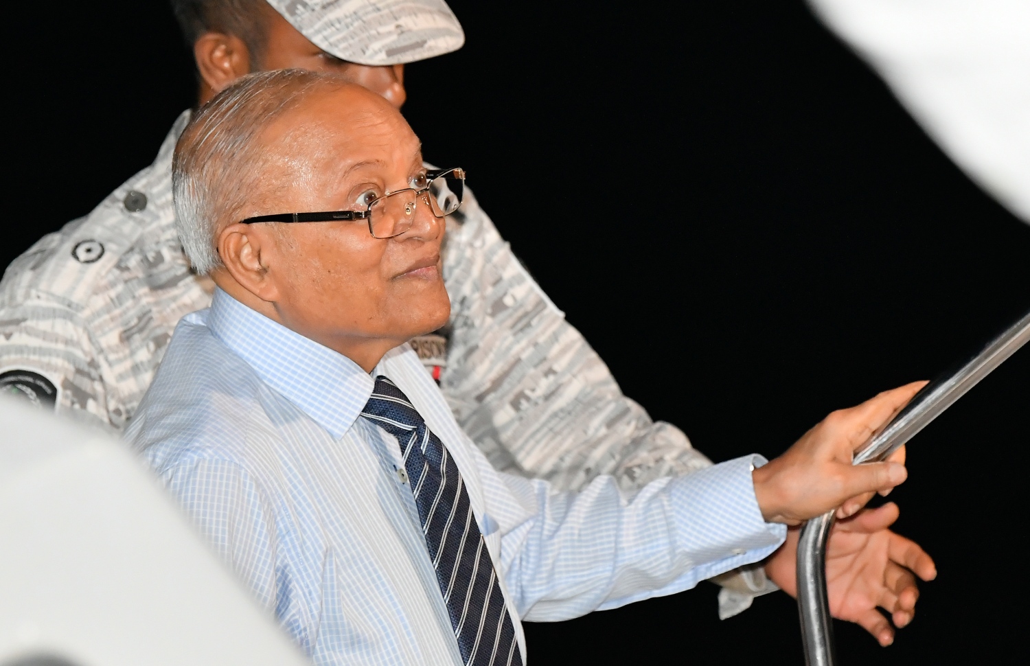 މާލެ: ސެޕްޓެމްބަރު 30، 2018- ގާނޫނާ ޚިލާފަށް ވެރިކަން ވައްޓާލަން އުޅުނު ކަމުގެ ތުހުމަތުގައި ހައްޔަރުކުރުމަށްފަހު މާފުށީ ޖަލުގައި ހުކުމް ތަންފީޒު ކުރައްވަމުން ގެންދެވި ކުރީގެ ރައީސް މައުމޫން އަބްދުލްގައްޔޫމް، މާފުށިން މާލެ ވަޑައިގަތުމަށްފަހު ލޯންޗުން ފައިބާވަޑައިގަންނަވަނީ---ފޮޓޯ: ހުސައިން ވަހީދު/މިހާރު