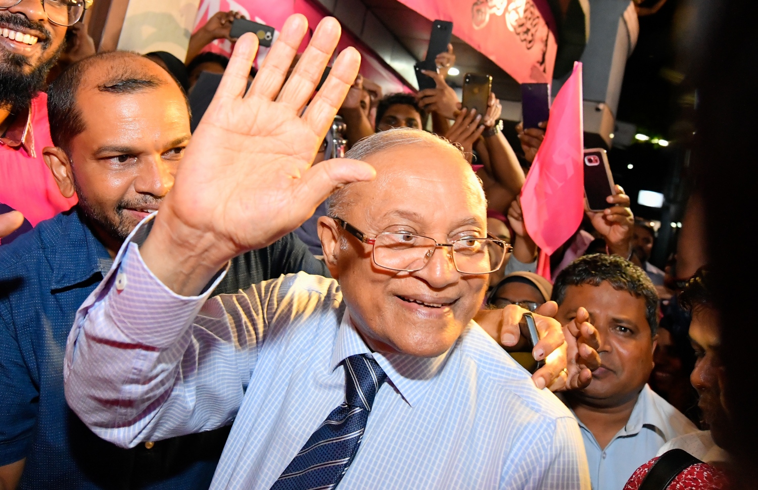 މާލެ: ސެޕްޓެމްބަރު 30، 2018- ގާނޫނާ ޚިލާފަށް ވެރިކަން ވައްޓާލަން އުޅުނު ކަމުގެ ތުހުމަތުގައި ހައްޔަރުކުރުމަށްފަހު މާފުށީ ޖަލުގައި ހުކުމް ތަންފީޒު ކުރައްވަމުން ގެންދެވި ކުރީގެ ރައީސް މައުމޫން އަބްދުލްގައްޔޫމް ކަފާލާތުގެ ދަށުން މިނިވަންވެ ވަޑައިގަތުމަށްފަހު އެންދެރިމާގެއަށް ވަޑައިގަތުމަށްފަހު އެމަނިކުފާނަށް މަރުހަބާ ދެންނެވުމަށް އެސަރަހައްދަށް އެއްވެ ތިބި މީހުންނަށް އަތުން އިޝާރާތްކުރައްވާ ސަލާމްކުރައްވަނީ---ފޮޓޯ: ހުސައިން ވަހީދު/މިހާރު