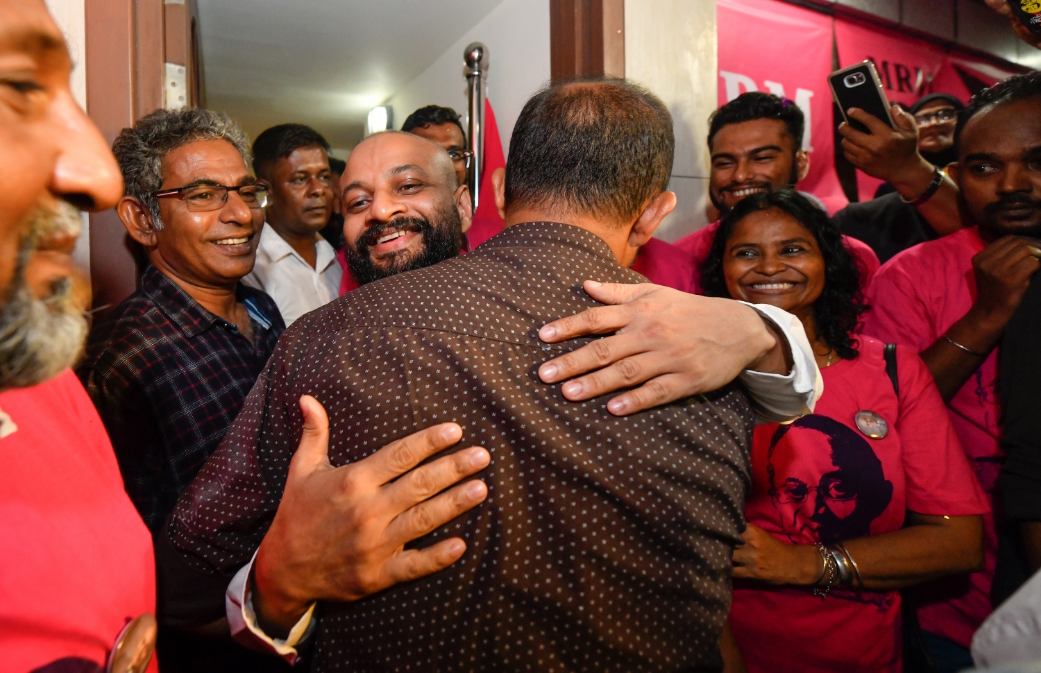 މާލެ: ސެޕްޓެމްބަރު 30، 2018- ޝަހްސު އޮޅުވާލުމުގެ ދައުވާއެއް ސާބިތުވެ، ހަތަރު މަހާއި 24 ދުވަހުގެ ޖަލު ހުކުމެއް ތަންފީޒު ކުރަމުންދިޔަ ދިއްގަރު ދާއިރާގެ މެމްބަރު އަދި މައުމޫންގެ ދަރިކަލުން އަހުމަދު ފާރިސް މައުމޫން ކަފާލާތުގެ ދަށުން ބަންދުން މިނިވަންވެ ވަޑައިގަތުމަށްފަހު ގެކޮޅަށް ވަޑައިގަތުމުން، ފާރިސްއަށް މަރުހަބާ ކިޔުމުގެ ގޮތުން އެ ސަރަހައްދަށް އެއްވެ ތިބި މީހުންގެ ތެރެއިން ކެންދޫ ދާއިރާގެ މެމްބަރު އަލީ ހުސައިނާ ސަލާމް ކުރެއްވުމަށް ފަހު ބައްދާލައްވަނީ.---ފޮޓޯ: ހުސައިން ވަހީދު/ މިހާރު