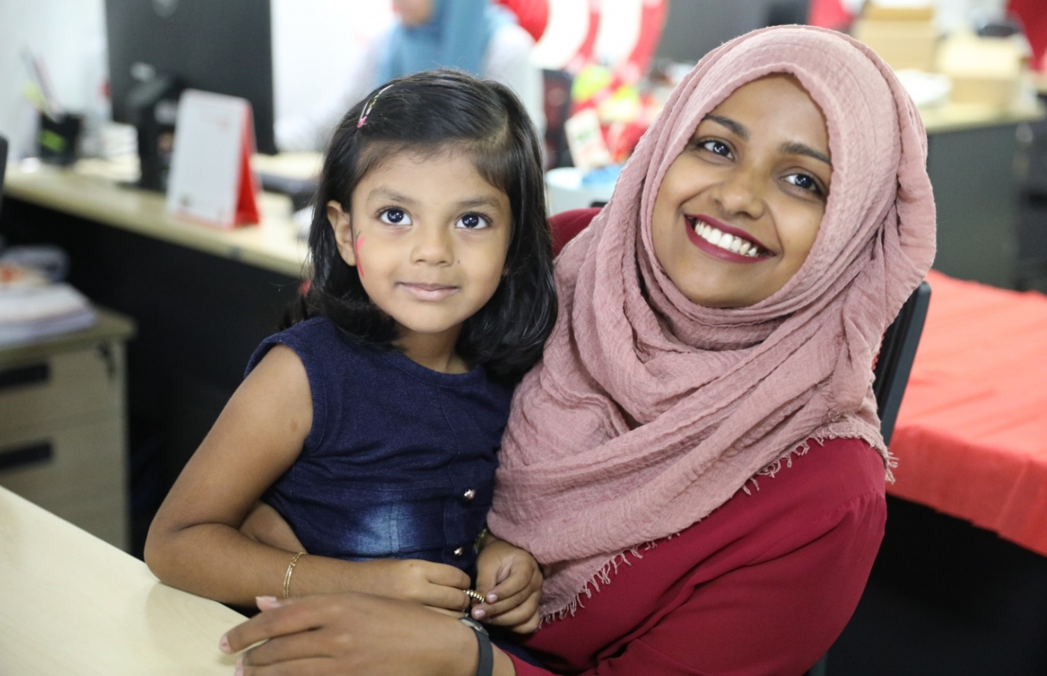 ބީއެމްއެލްގެ "ބްރިންގް ޔޯ ކިޑްސް ޓު ވޯކް ޑޭ"ގައި އެ ބޭންކުގެ މުވައްޒަފެއް ދަރިއަކު އުރާލައިގެން ބޭންކުގެ ތެރޭގައި. -- ފޮޮޓޯ: ބީއެމްއެލް