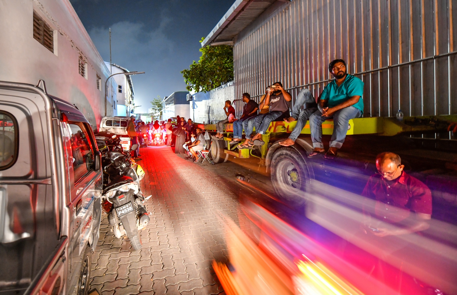 މާލެ: އޮކްޓޯބަރު 10، 2018: ހުޅުމާލޭގެ ދެ ވަނަ ފިޔަވަހިން 400 ގޯތި ގަންނަން ބޭނުންވާ މީހުންނަށް އެ ފުރުސަތު ހުޅުވާލުމާ އެކު، ހައުސިން މިނިސްޓްރީ ކައިރީގައި ދަމާލި ކިޔޫ ދިގުދެމިގެން އައިސް މިއަދު ދޫކުރި 500 ނަމްބަރު ހުސްވުމުން، މާދަމާ ދޫކުރާ 500 ނަމްބަރުގައި ލައްވާލާތޯ މިރޭގެ ނިދި ނަގާލުމަށްފަހު ގިނައަދަދެއްގެ މީހުން ހައުސިން މިނިސްޓްރީ ހުންނަ އިމާރާތާ ޖެހިގެން ހުންނަ އެސްޓީއޯ ގުދަންތައް ކައިރި މާދަމާގެ ކިޔޫގައި މަޑުކޮށްގެންތިބި އިރު ބައެއް މީހުން ޕާކުކޮށްފައިހުރި ޕިކަޕެއްގެ މަތީގައި އިށީނދެލައިގެން،---ފޮޓޯ: ހުސައިން ވަހީދު/މިހާރު