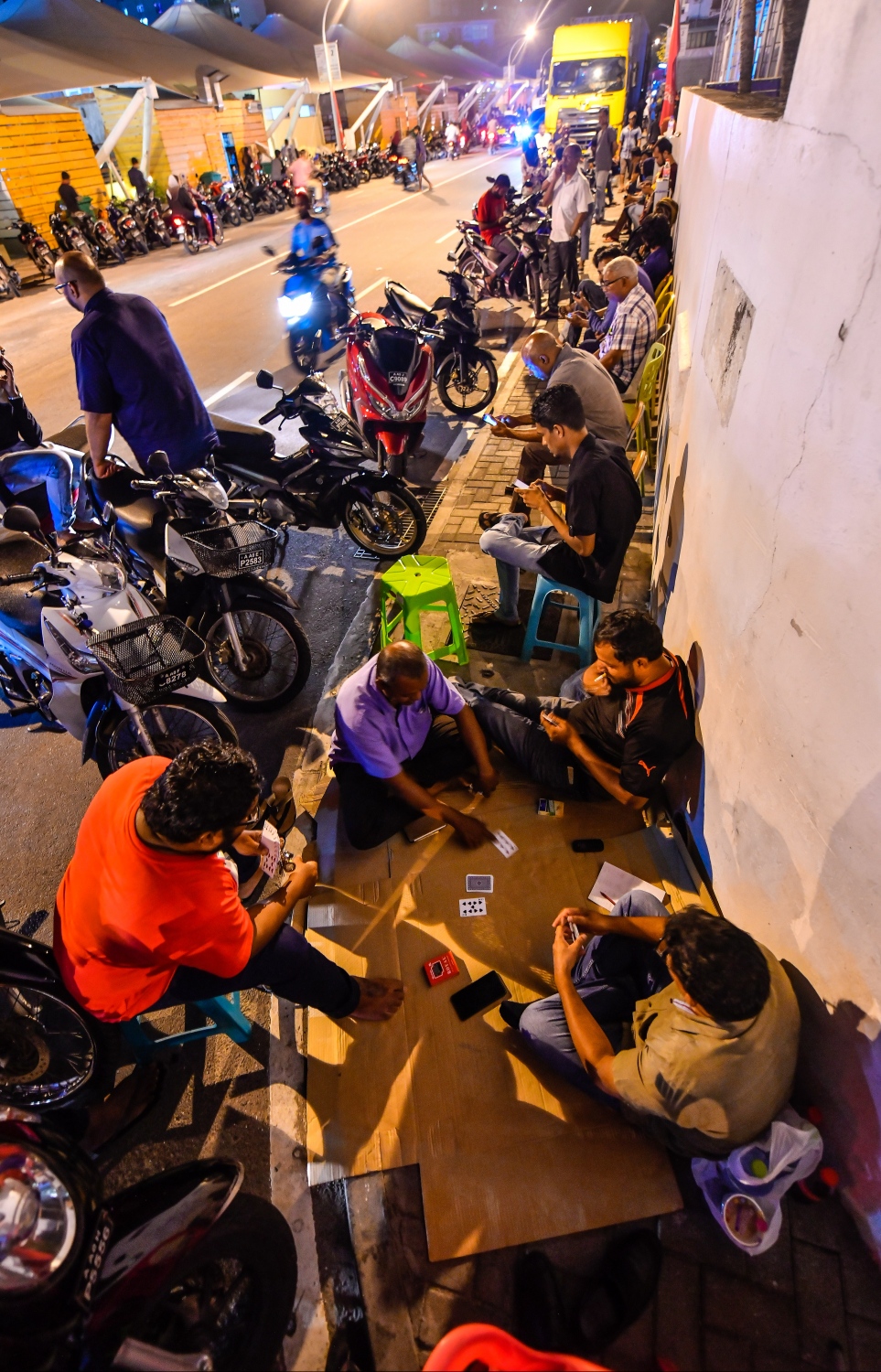 މާލެ: އޮކްޓޯބަރު 10، 2018: ހުޅުމާލޭގެ ދެ ވަނަ ފިޔަވަހިން 400 ގޯތި ގަންނަން ބޭނުންވާ މީހުންނަށް އެ ފުރުސަތު ހުޅުވާލުމާ އެކު، ހައުސިން މިނިސްޓްރީ ކައިރީގައި ދަމާލި ކިޔޫ ދިގުދެމިގެން އައިސް މިއަދު ދޫކުރި 500 ނަމްބަރު ހުސްވުމުން، މާދަމާ ދޫކުރާ 500 ނަމްބަރުގައި ލައްވާލާތޯ މިރޭގެ ނިދި ނަގާލުމަށްފަހު މާދަމާގެ ކިޔޫގައި މަގުމަތީ މަޑުކޮށްގެންތިބި ބަޔަކު ފޫހި ފިލުވުމުގެ ގޮތުން ތާސްކުޅެނީ،---ފޮޓޯ: ހުސައިން ވަހީދު/މިހާރު