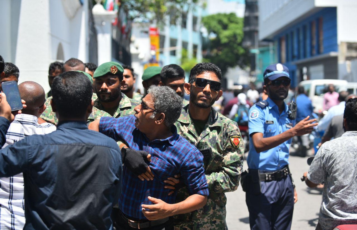 މާލެ: އޮކްޓޯބަރު 14، 2018: ސުޕްރީމް ކޯޓުގެ ހުޅަނގު ކަންމަތިން ކުރިމަތީގައި ހުންނަ ޔުނިވާސަލްގެ އިމާރާތުގެ ގޯޅިގަނޑަށް އެއްވެފައި ތިބި މީހުން ފަހަތަށް ޖެއްސުމަށް އެސްއޯ ފުލުހުންނާއި ސިފައިން ހަރަކާތްތެރިވަނީ.---ފޮޓޯ: އަހުމަދު ނިޝާތު/މިހާރު