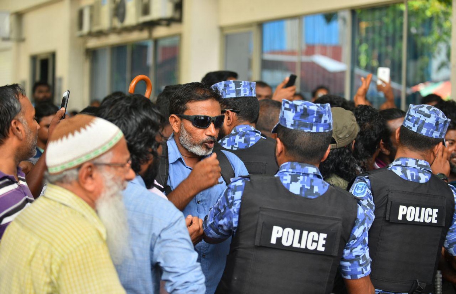 ސުޕްރީމް ކޯޓުގެ ހުޅަނގު ކަންމަތިން ކުރިމަތީގައި ހުންނަ ޔުނިވާސަލްގެ އިމާރާތުގެ ގޯޅިގަނޑަށް އެއްވެފައި ތިބި މީހުން ފަހަތަށް ޖެއްސުމަށް އެސްއޯ ފުލުހުން މިއަދު ހަރަކާތްތެރިވަނީ.---ފޮޓޯ: އަހުމަދު ނިޝާތު/މިހާރު