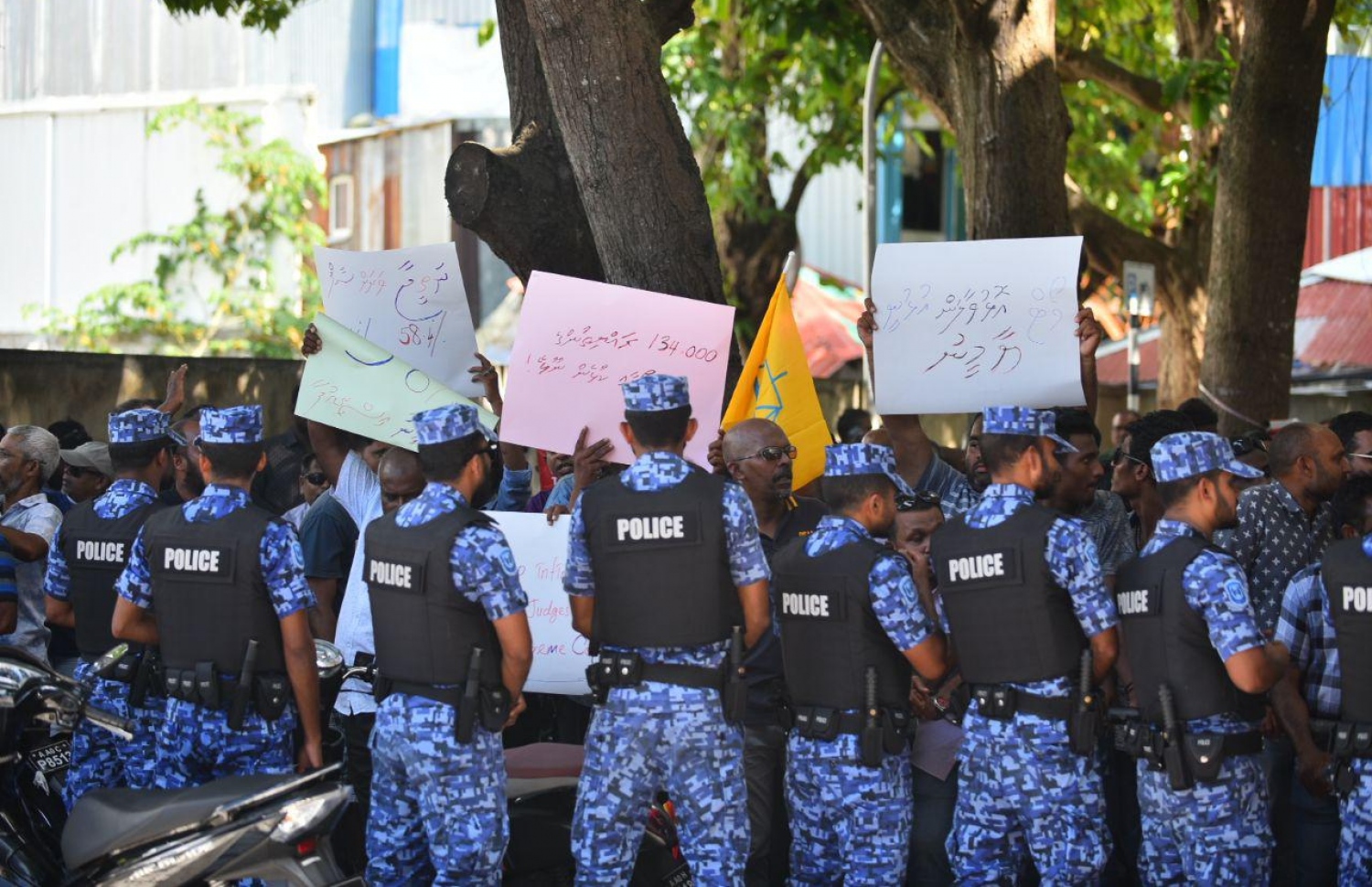 މާލެ: އޮކްޓޯބަރު 14، 2018: ސުޕްރީމް ކޯޓުގެ ހުޅަނގު ކަންމަތިން ކުރިމަތީގައި ހުންނަ ޔުނިވާސަލްގެ އިމާރާތުގެ ގޯޅިގަނޑަށް އެއްވެފައި ތިބި މީހުން ފަހަތަށް ޖެއްސުމަށް އެސްއޯ ފުލުހުންނާއި ސިފައިން ހަރަކާތްތެރިވަނީ.---ފޮޓޯ: އަހުމަދު ނިޝާތު/މިހާރު