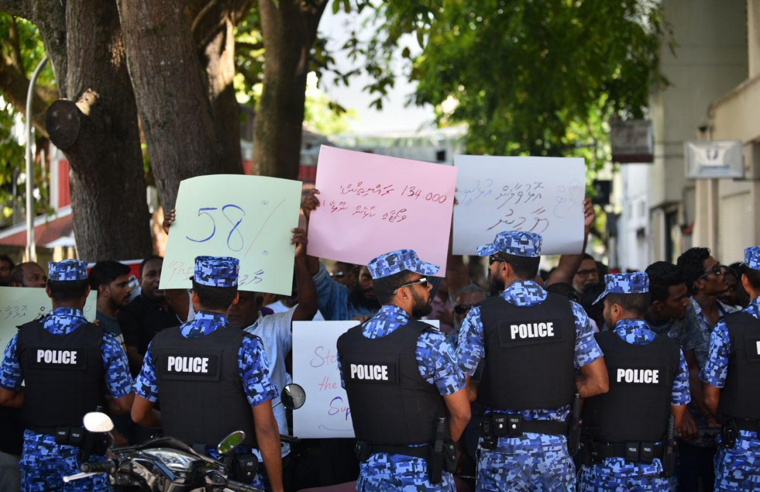 މާލެ: އޮކްޓޯބަރު 14، 2018: ސުޕްރީމް ކޯޓުގެ ހުޅަނގު ކަންމަތިން ކުރިމަތީގައި ހުންނަ ޔުނިވާސަލްގެ އިމާރާތުގެ ގޯޅިގަނޑަށް އެއްވެފައި ތިބި މީހުން ފަހަތަށް ޖެއްސުމަށް އެސްއޯ ފުލުހުންނާއި ސިފައިން ހަރަކާތްތެރިވަނީ.---ފޮޓޯ: އަހުމަދު ނިޝާތު/މިހާރު