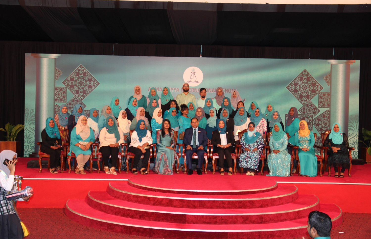 މާލެ: އޮކްޓޯބަރު 20، 2018: ދަރުބާރުގޭގައި ބޭއްވި އަހުމަދިއްޔާ އިންޓަނޭޝަނަލް ސްކޫލުގެ އިނާމު ދިނުމުގެ ޖަލްސާގައި، ސްކޫލުގެ އިސްވެރިންނާއި ބައެއް ޓީޗަރުން ބައިވެރިވެ ވަޑައިގަންނަވަނީ.-- ފޮޓޯ: އަހުމަދިއްޔާ އިންޓަނޭޝަންލް ސްކޫލް