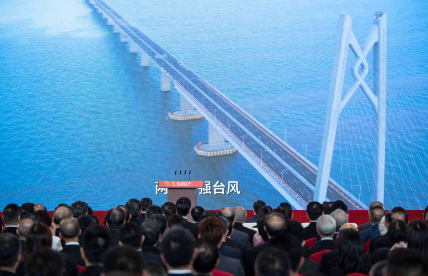 ހޮންކޮން-ޒުހައި-މަކާއޫ ބްރިޖް ބޮޑު ސްކްރީނަކުން ބަޔަކު ބަލަނީ. --ފޮޓޯ:އޭއެފްޕީ