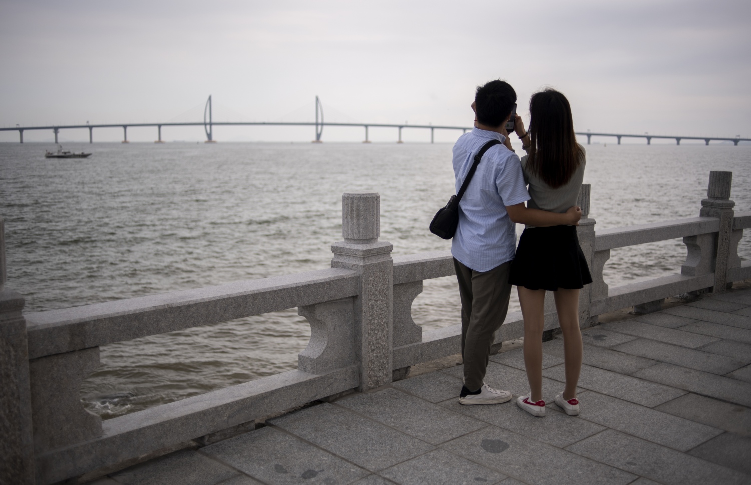 ހޮންކޮން-ޒުހައި-މަކާއޫ ބްރިޖުގެ ފޮޓޯއަކަށް ދެ މީހަކު ތައްޔާރުވެގެން. --ފޮޓޯ:އޭއެފްޕީ