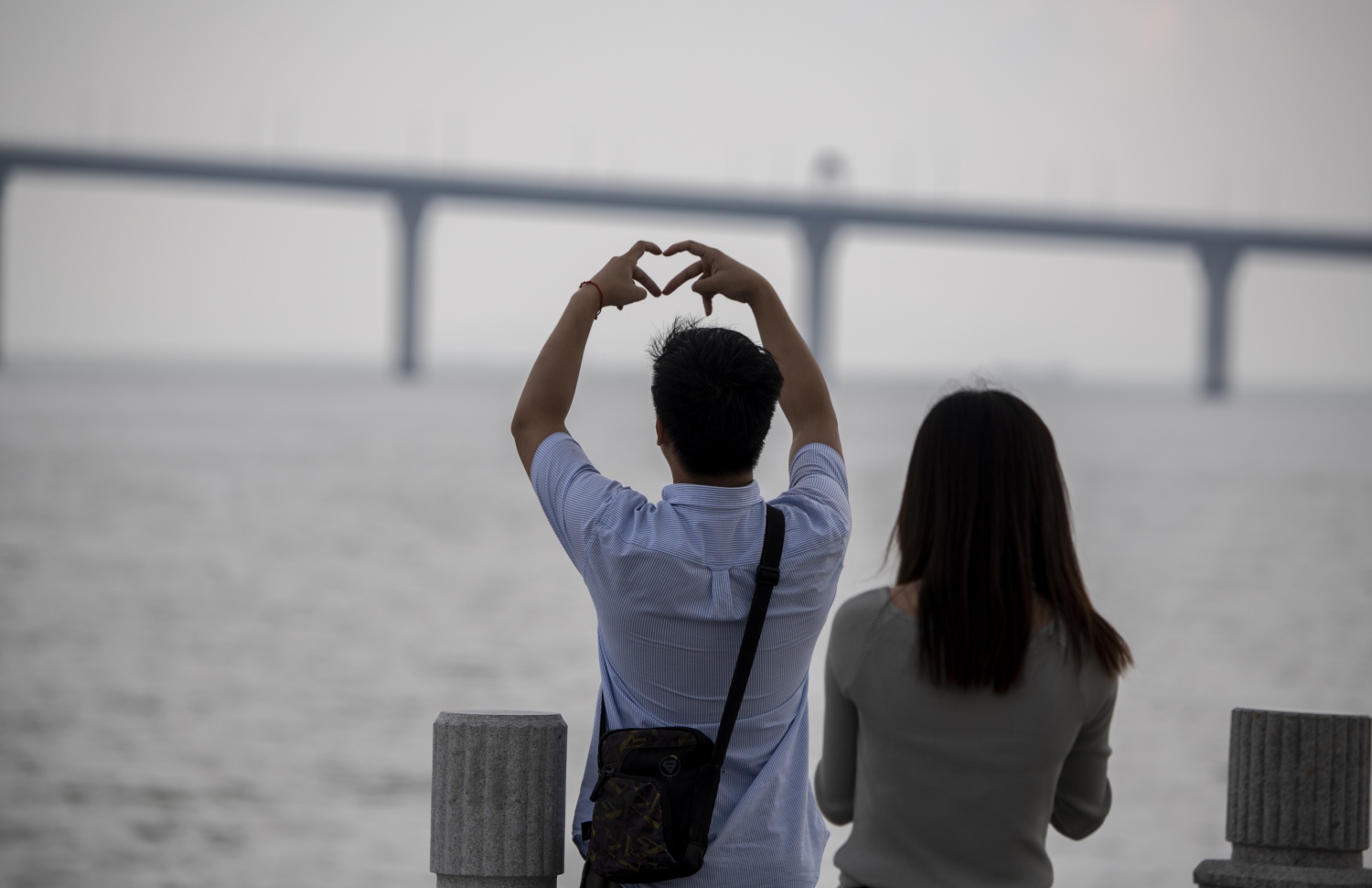 ހޮންކޮން-ޒުހައި-މަކާއޫ ބްރިޖުގެ ފޮޓޯއަކަށް ދެ މީހަކު ތައްޔާރުވެގެން. --ފޮޓޯ:އޭއެފްޕީ