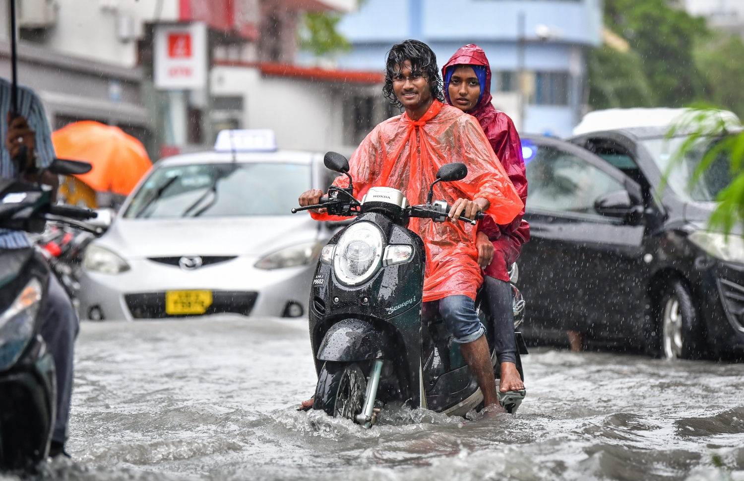 މާލެ: އޮކްޓޯބަރު 28، 2018- މާލެ އަށް މިއަދު ހެނދުނުއްސުރެ ފެށިގެން ވެހެމުންދާ ބޯ ވާރޭގެ ތެރޭގައި ދެ މީހަކު ވާރޭ ކޯޓުލައިގެން، ފެން ބޮޑުވެފައިވާ މަގެއްގައި ސައިކަލްގައި ދަނީ: މާލޭގެ ބައެއް މަގުތަކުގައި މިއަދު ވަނީ އާދަޔާ ޚިލާފަށް ފެން ބޮޑުވެ، ހިނގައިބިނގައި އުޅުމަށް ބޮޑެތި ދަތިތަކެއް ކުރިމަތިވެފައި.---ފޮޓޯ: ނިޝާން އަލީ/މިހާރު