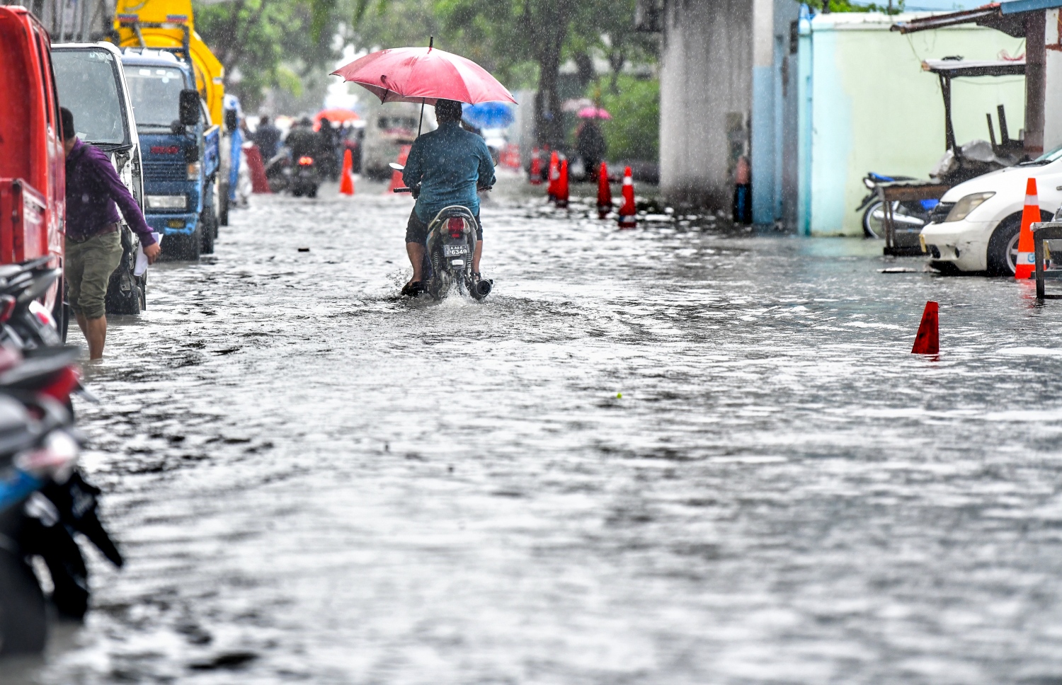 މާލެ: އޮކްޓޯބަރު 28، 2018- މާލެ އަށް މިއަދު ހެނދުނުއްސުރެ ފެށިގެން ވެހެމުންދާ ބޯ ވާރޭގެ ތެރޭގައި މީހަކު ކުޑަ އަޅައިގެން، ފެން ބޮޑުވެފައުވާ މަގެއްގައި ސައިކަލްގައި ދަނީ: މާލޭގެ ބައެއް މަގުތަކުގައި މިއަދު ވަނީ އާދަޔާ ޚިލާފަށް ފެން ބޮޑުވެ، ހިނގައިބިނގައި އުޅުމަށް ބޮޑެތި ދަތިތަކެއް ކުރިމަތިވެފައި.---ފޮޓޯ: ނިޝާން އަލީ/މިހާރު