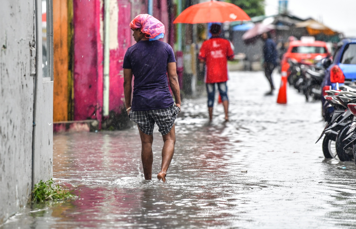 މާލެ: އޮކްޓޯބަރު 28، 2018- މާލެ އަށް މިއަދު ހެނދުނުއްސުރެ ފެށިގެން ވެހެމުންދާ ބޯ ވާރެއާ ގުޅިގެން، ފެން ބޮޑުވެފައިވާ މަގެއްގައި ބަޔަކު ހިނގާފައި ދަނީ: މާލޭގެ ބައެއް މަގުތަކުގައި މިއަދު ވަނީ އާދަޔާ ޚިލާފަށް ފެން ބޮޑުވެ، ހިނގައިބިނގައި އުޅުމަށް ބޮޑެތި ދަތިތަކެއް ކުރިމަތިވެފައި.---ފޮޓޯ: ނިޝާން އަލީ/މިހާރު