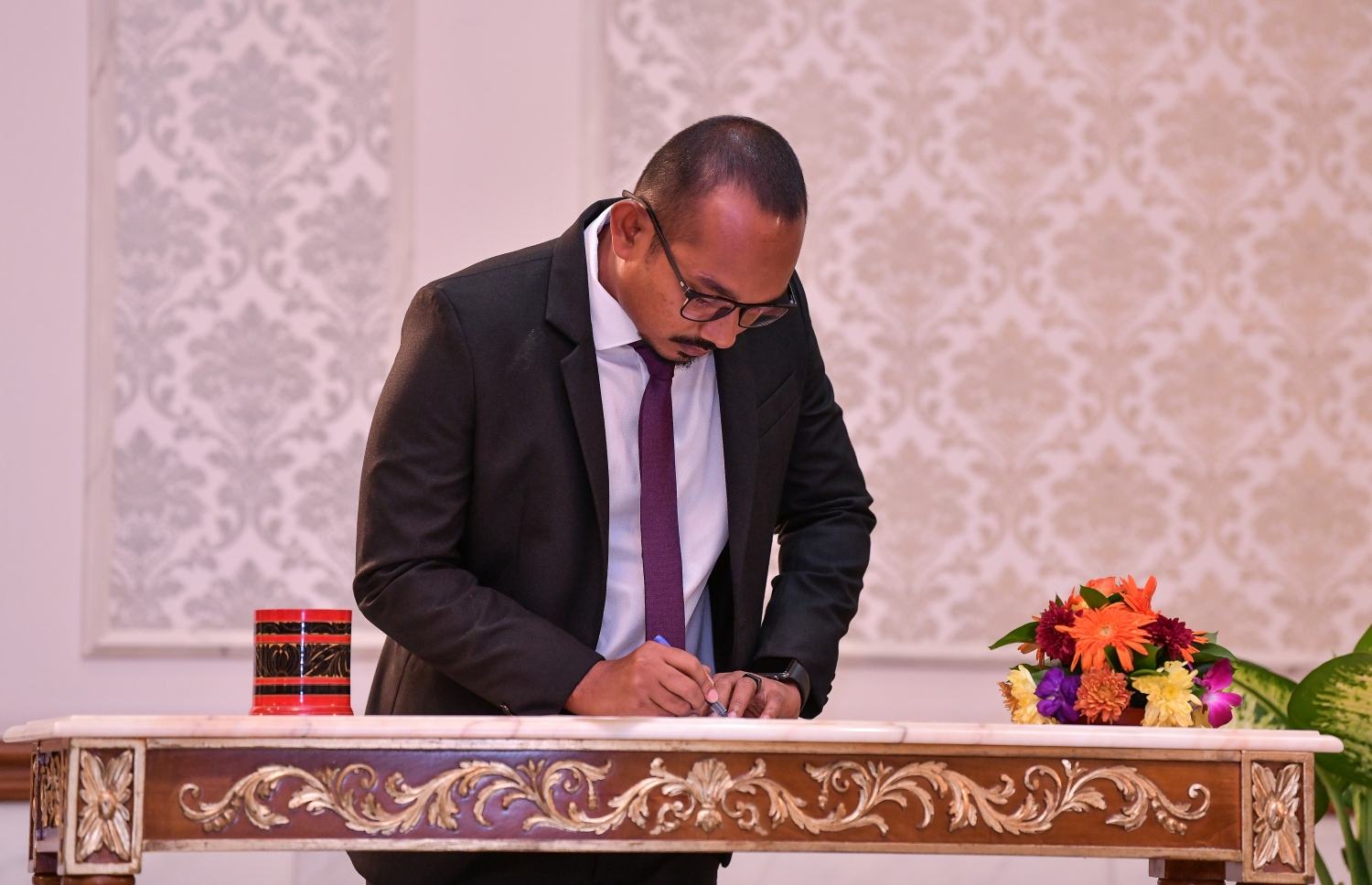 މާލެ: އޮކްޓޯބަރު 29، 2018: ރަށްރަށުގެ މެޖިސްޓްރޭޓް ކޯޓުތަކަށް 15 މެޖިސްޓްރޭޓަކު އައްޔަން ކުރައްވައި އެ ބޭފުޅުން މަގާމުގެ ހުވާ ކުރައްވުމަށް ރޭ ސުޕްރީމް ކޯޓްގައި ބޭއްވި ރަސްމިއްޔާތުގައި މެޖިސްޓްރޭޓް ކަމަށް އައްޔަން ކުރި ބޭފުޅަކު މެޖިސްޓްރޭޓް ކަމުގެ ހުވާ ކުރެއްވުމަށްފަހު ފަތްކޮޅުގައި ސޮއި ކުރައްވަނީ--. ފޮޓޯ: ނިޝާން އަލީ/މިހާރު