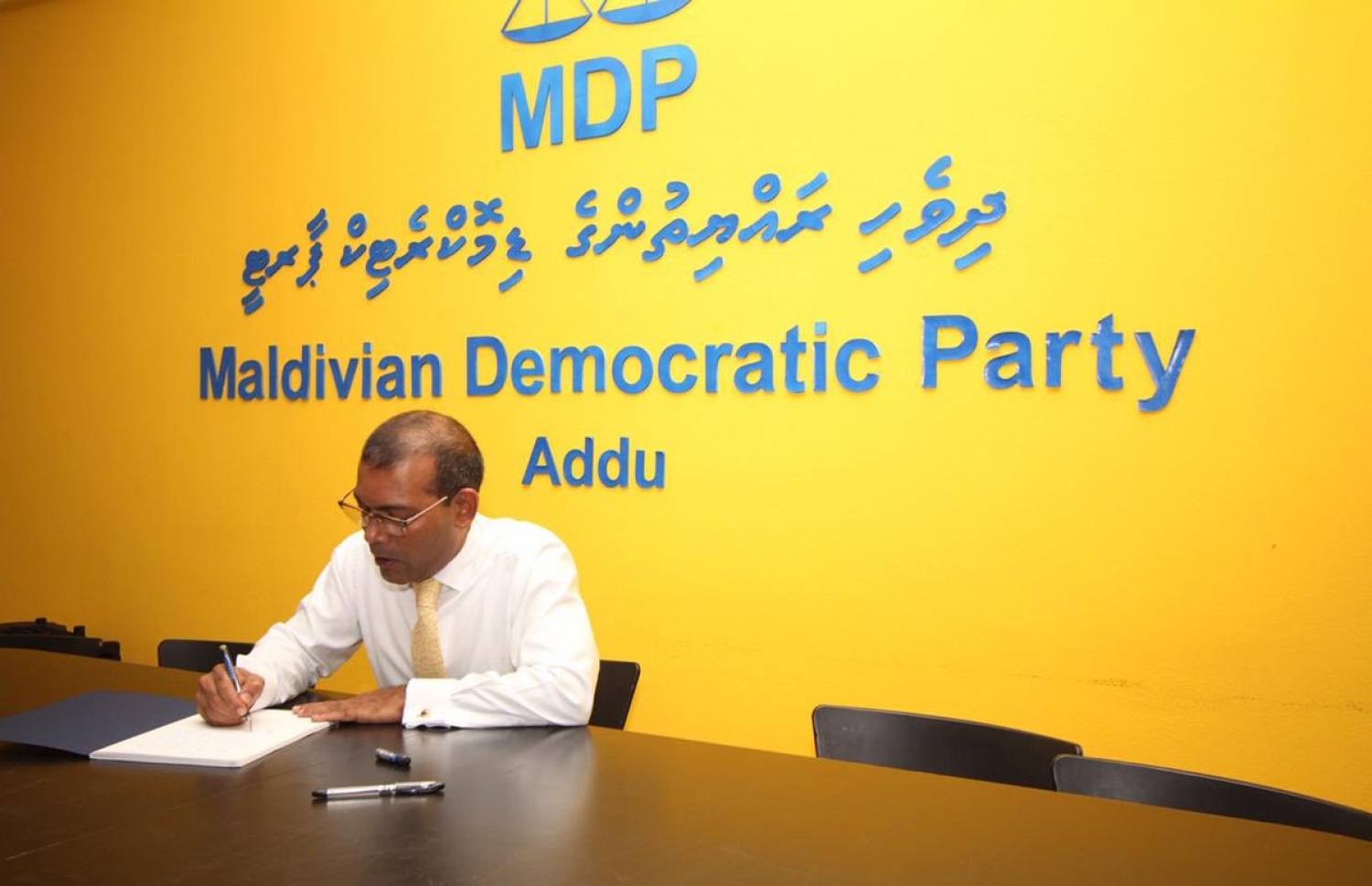 އައްޑޫ :ނޮވެމްބަރު 5، 2018: ކުރީގެ ރައީސް މުހައްމަދު ނަޝީދު އައްޑޫއަށް ކުރެއްވި ދަތުރުފުޅުގައި، ނަޝީދުގެ އައްޑޫގައި ގާއިމްކުރި އޮފީސް ހުޅުވައި ދެއްވުމަށްފަހު ލިޔުމެއްގައި ސޮއި ކުރައްވަނީ.-- ފޮޓޯ: އެމްޑީޕީ