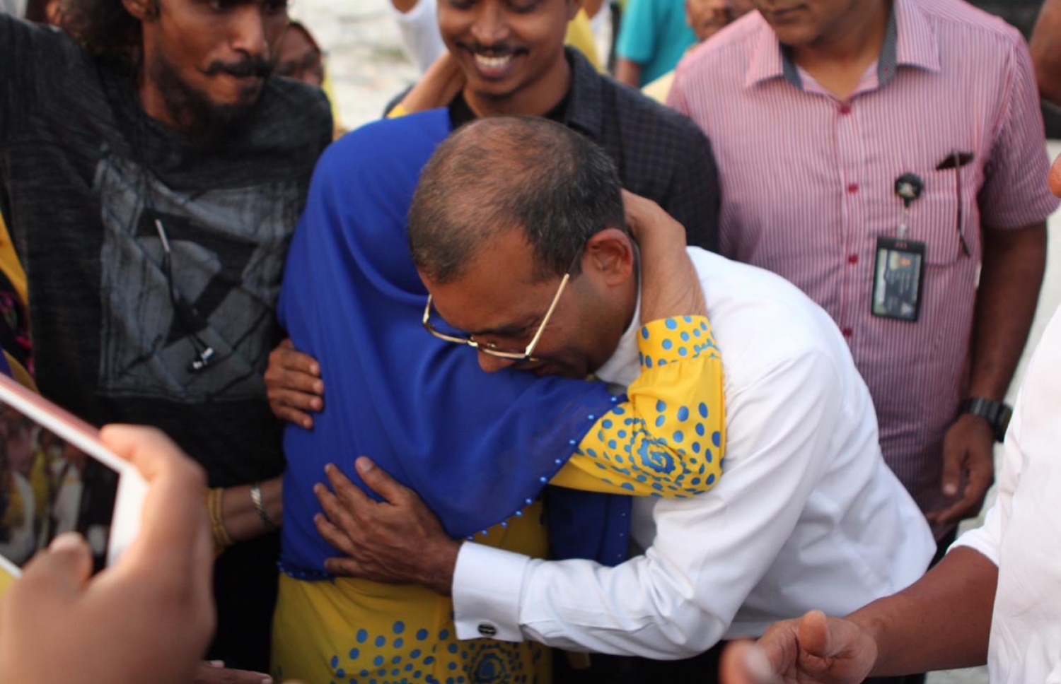 އައްޑޫ :ނޮވެމްބަރު 5، 2018: ކުރީގެ ރައީސް މުހައްމަދު ނަޝީދު އައްޑޫއަށް ކުރެއްވި ދަތުރުފުޅުގައި ނަޝީދަށް މަރުހަބާ ކިއުމަށް އެއްވެ ތިބި މީހުންގެ ތެރެއިން، އުމުރުން ދުވަސްވީ އަންހެނެއްގެ ގައިގައި ބައްދާލަނީ.-- ފޮޓޯ: އެމްޑީޕީ