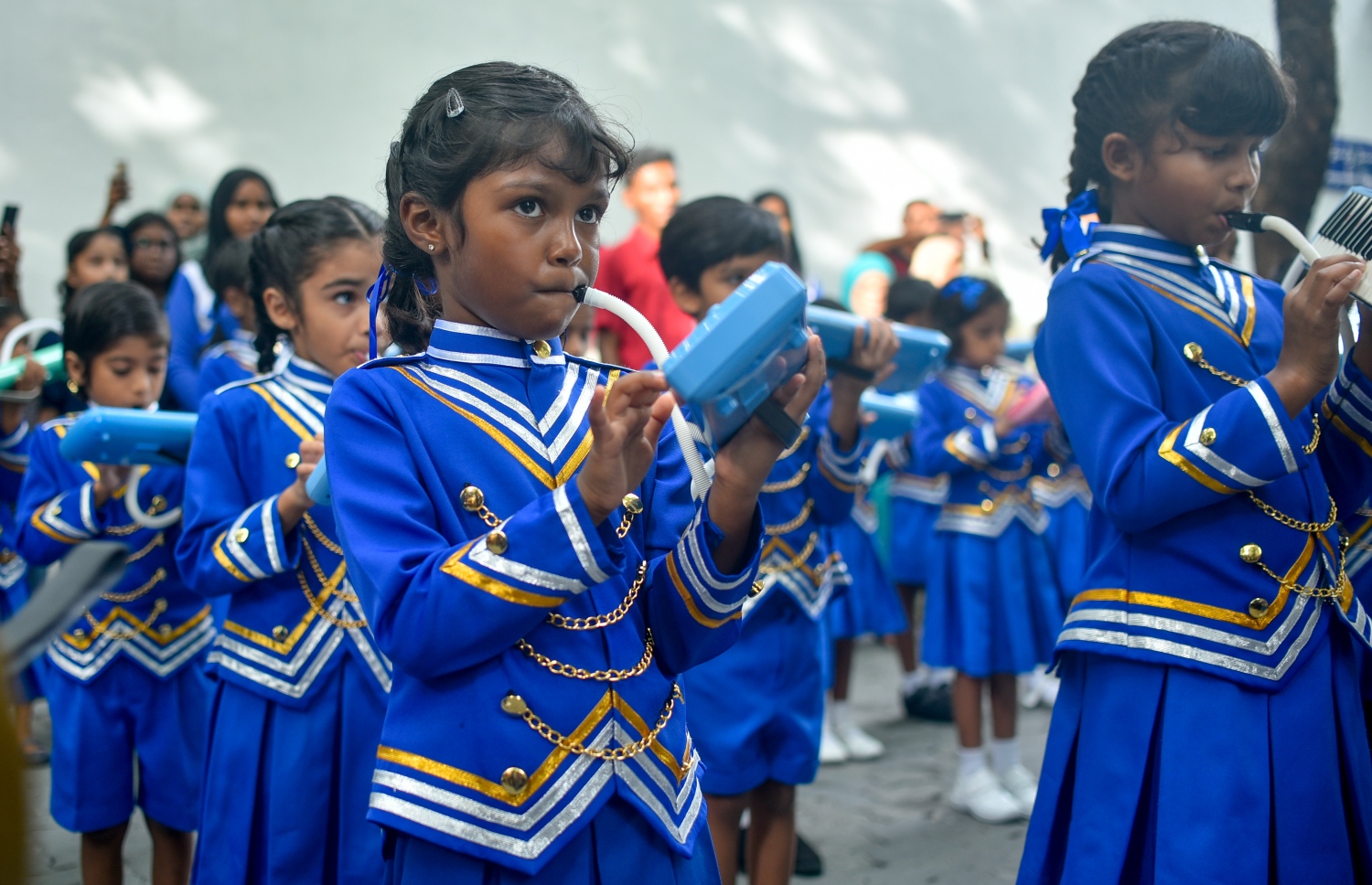 ބޭންޑްގެ ކުދިން މެލޮޑިކާ ކުޅެނީ. އާންމުންގެ ގިނަ ބަޔަކު ތިބެނީ ހައިރާންވެފައި. --- ފޮޓޯ: އަހުމަދު ނިޝާތު/ މިހާރު