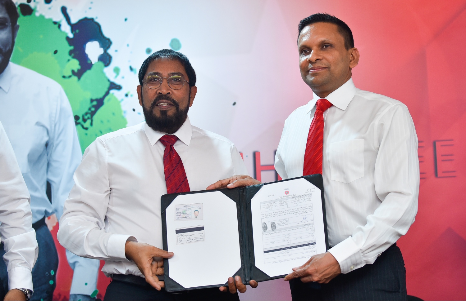 ޖޭޕީއަށް ސޮއިކުރެއްވުމަށް ފަހު، ނާޒިމް އޭނާގެ ފޯމު ގާސިމްއާ ހަވާލު ކުރައްވަނީ.---ފޮޓޯ: ހުސައިން ވަހީދު/މިހާރު