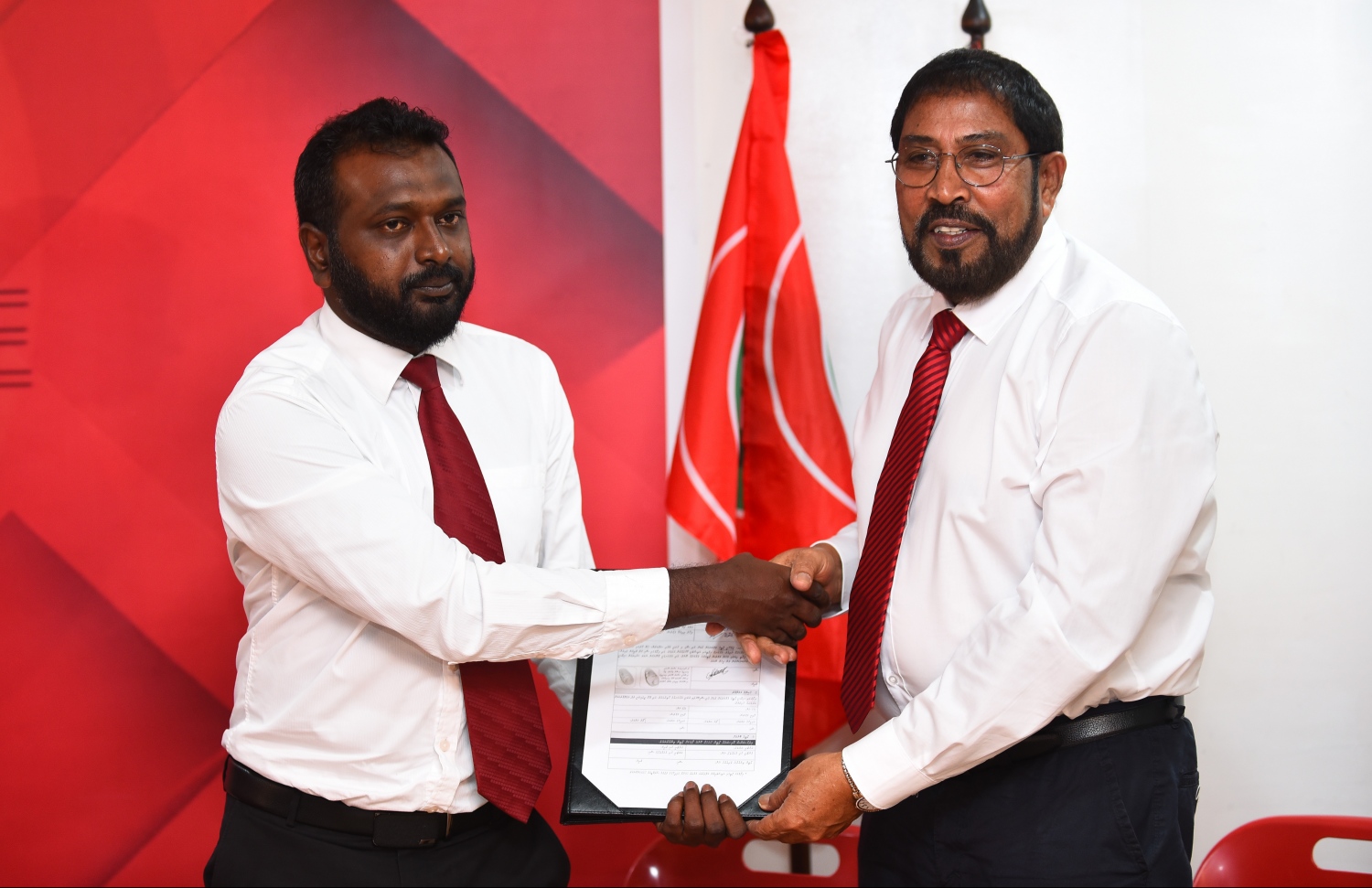 އަޒްހާން މިރޭ ޖޭޕީއަށް ސޮއިކުރެއްވުމަށް ފަހު، އެ ޕާޓީގެ ލީޑަރު ގާސިމްއާ ފޯމު ހަވާލު ކުރައްވަނީ.---ފޮޓޯ: ހުސައިން ވަހީދު/މިހާރު