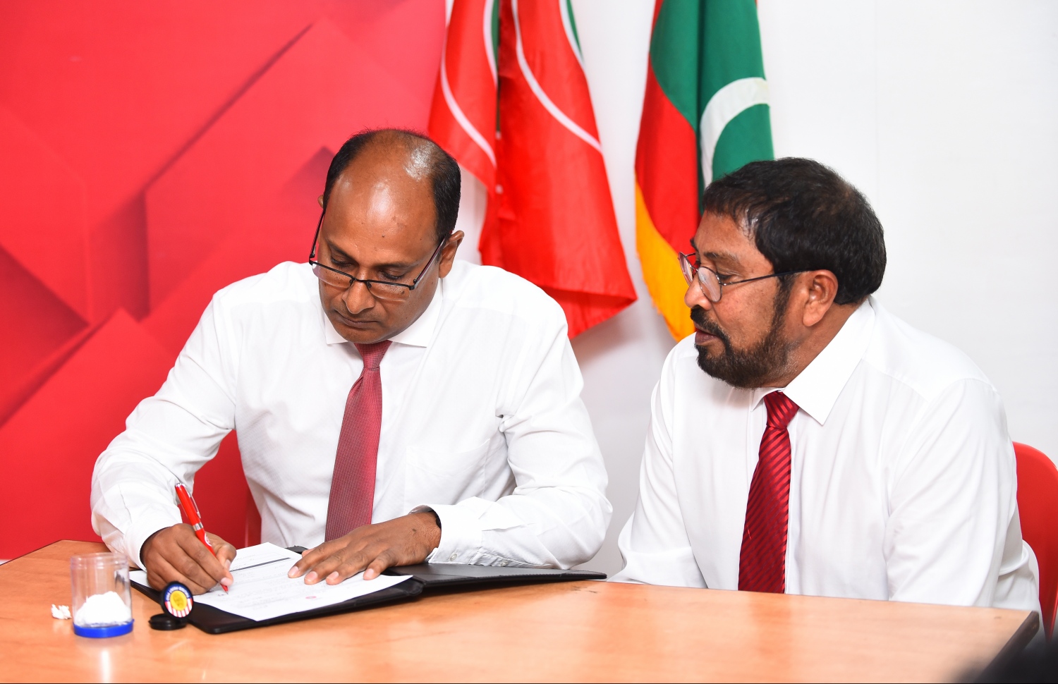 މާލެ: ނޮވެމްބަރު 25، 2018- ކުޑަކުދިންނަށް ޚާއްސަ ދީނީ ޕްރޮގްރާމް ހުށަހަޅުއްވާ އަބްދުއްލަތީފް އަހުމަދު ޖުމްހޫރީ ޕާޓީއަށް ސޮއިކުރައްވާއިރު، އެ ޕާޓީގެ ލީޑަރު ގާސިމް އެ ރަސްމިއްޔާތުގައި ބައިވެރިވެވަޑައިގަންނަވަނީ.---ފޮޓޯ: ހުސައިން ވަހީދު/މިހާރު