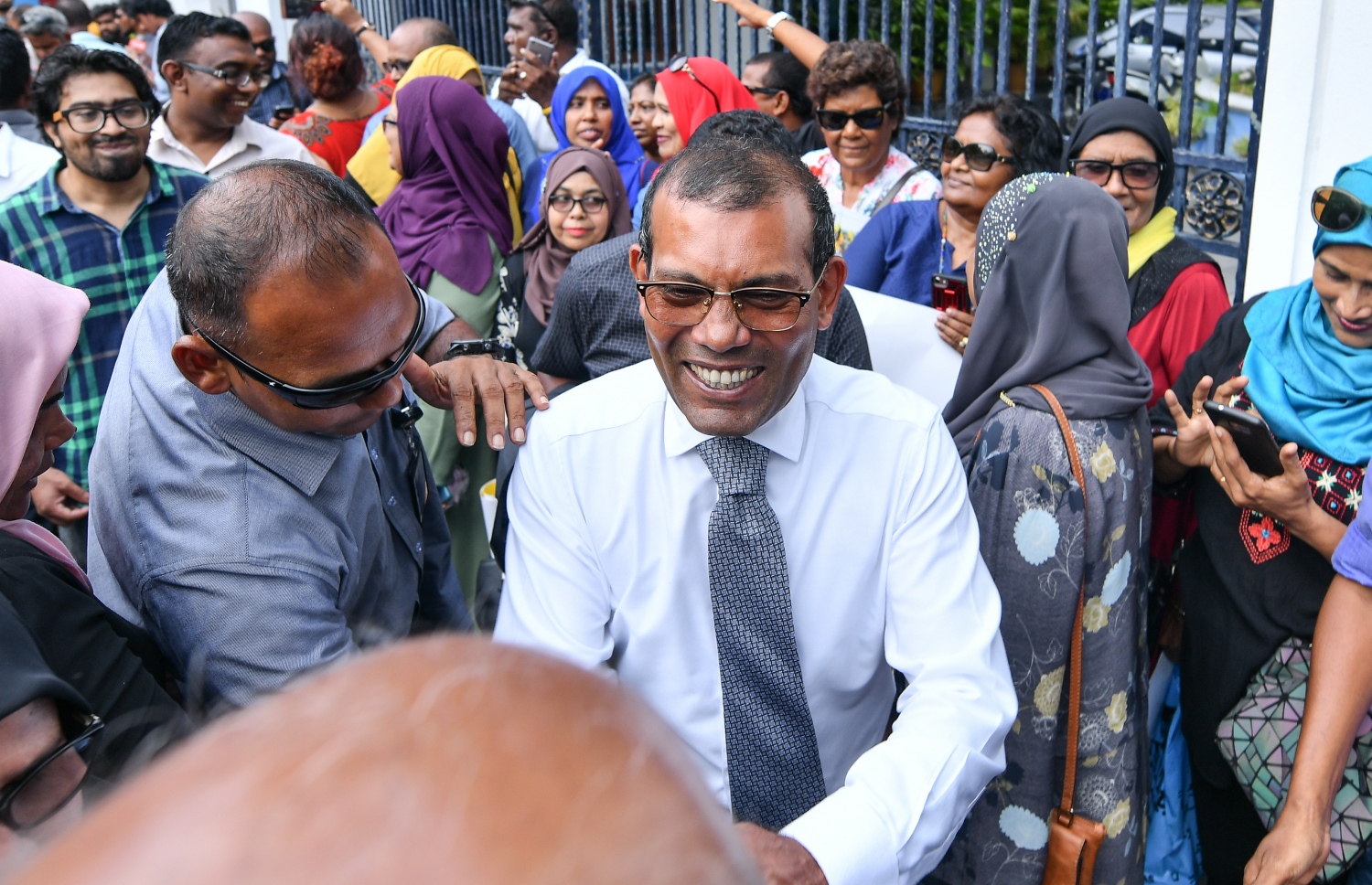 މާލެ: ނޮވެމްބަރު 26، 2018: ސުޕްރީމް ކޯޓުގައި އޮތް، ކުރީގެ ރައީސް މުހައްމަދު ނަޝީދުގެ އަޑުއެހުމަށް ފަހު، އެމަނިކުފާނު ކޯޓުން ނިކުމެ ވަޑައިގަން ސަޕޯޓަރުންނާ ސަލާމް ކުރައްވަނީ: ކޯޓުން ވަނީ އެމަނިކުފާނުގެ މައްޗަށް އިއްވި 13 އަހަރުގެ ޖަލު ހުކުމް ބާތިލް ކޮށްފައި.-- ފޮޓޯ: ނިޝާން އަލީ /މިހާރު