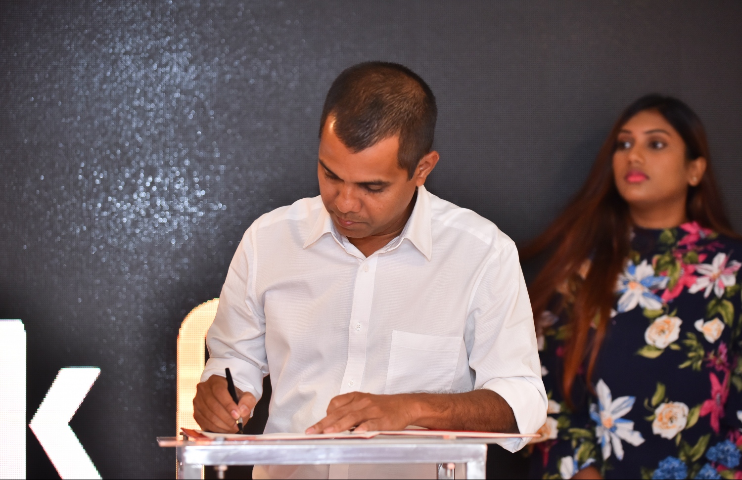 މާލެ: ނޮވެމްބަރު 27، 2018: ރާއްޖޭގެ އެންމެ ބޮޑު ކުޅިވަރު އެވޯޑްސް ކަމަށްވާ "މިހާރު އެވޯޑްސް"ގެ ސްޕޮންސަރުންނާއި ޕާޓްނަރުން އެއްބަސްވުމުގައި ސޮއިކުރުމުގެ ގޮތުން ޗަމްޕާ ސެންޓްރަލްގައި ބޭއްވި ހަފްލާގައި ތިންކުގެ ޗީފްގެ އެގްޒެކެޓިވް އޮފިސަރު އަދީލް އެއްބަސްވުމުގައި ސޮއިކުރައްވަނީ.--- ފޮޓޯ: ހުސައިން ވަހީދު/މިހާރު