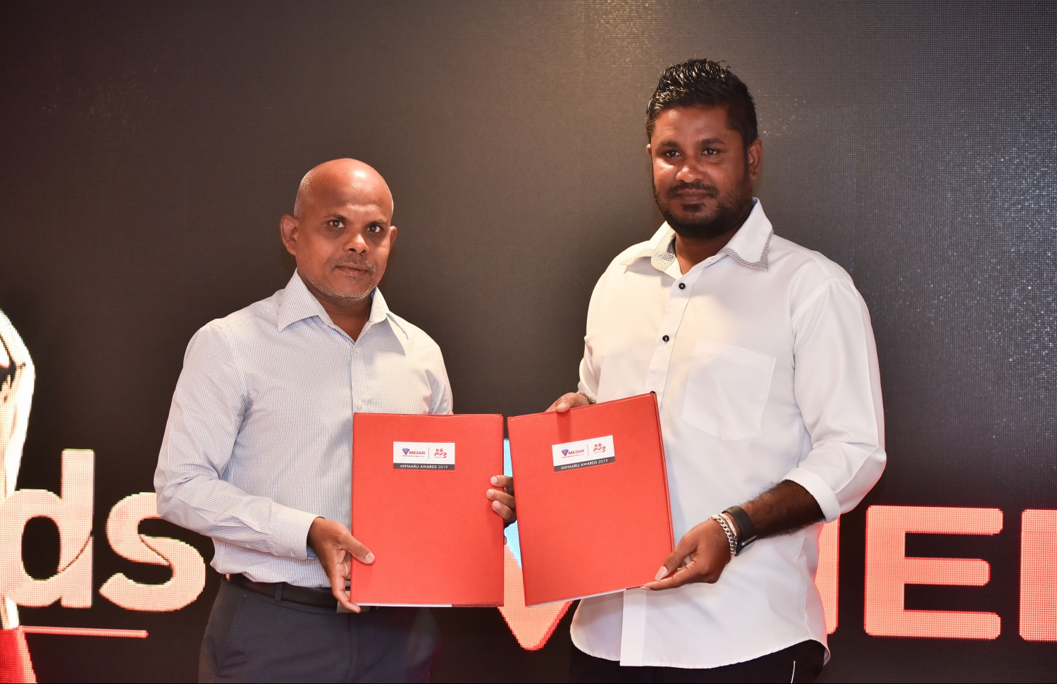 މާލެ: ނޮވެމްބަރު 27، 2018: ރާއްޖޭގެ އެންމެ ބޮޑު ކުޅިވަރު އެވޯޑްސް ކަމަށްވާ "މިހާރު އެވޯޑްސް"ގެ ސްޕޮންސަރުންނާއި ޕާޓްނަރުން އެއްބަސްވުމުގައި ސޮއިކުރުމުގެ ގޮތުން ޗަމްޕާ ސެންޓްރަލްގައި ބޭއްވި ހަފްލާގައި ވީޓީވީ ސްޕޯޓްސްގެ އިވެންޓްސް މެނޭޖަރު ހުސައިން ފަރިޔާޒް (ކ) އާއި މިހާރުގެ އެޑިޓަރު މޫސާ ލަތީފް އެއްބަސްވުން ދައްކާލައްވަނީ.--- ފޮޓޯ: ހުސައިން ވަހީދު/މިހާރު