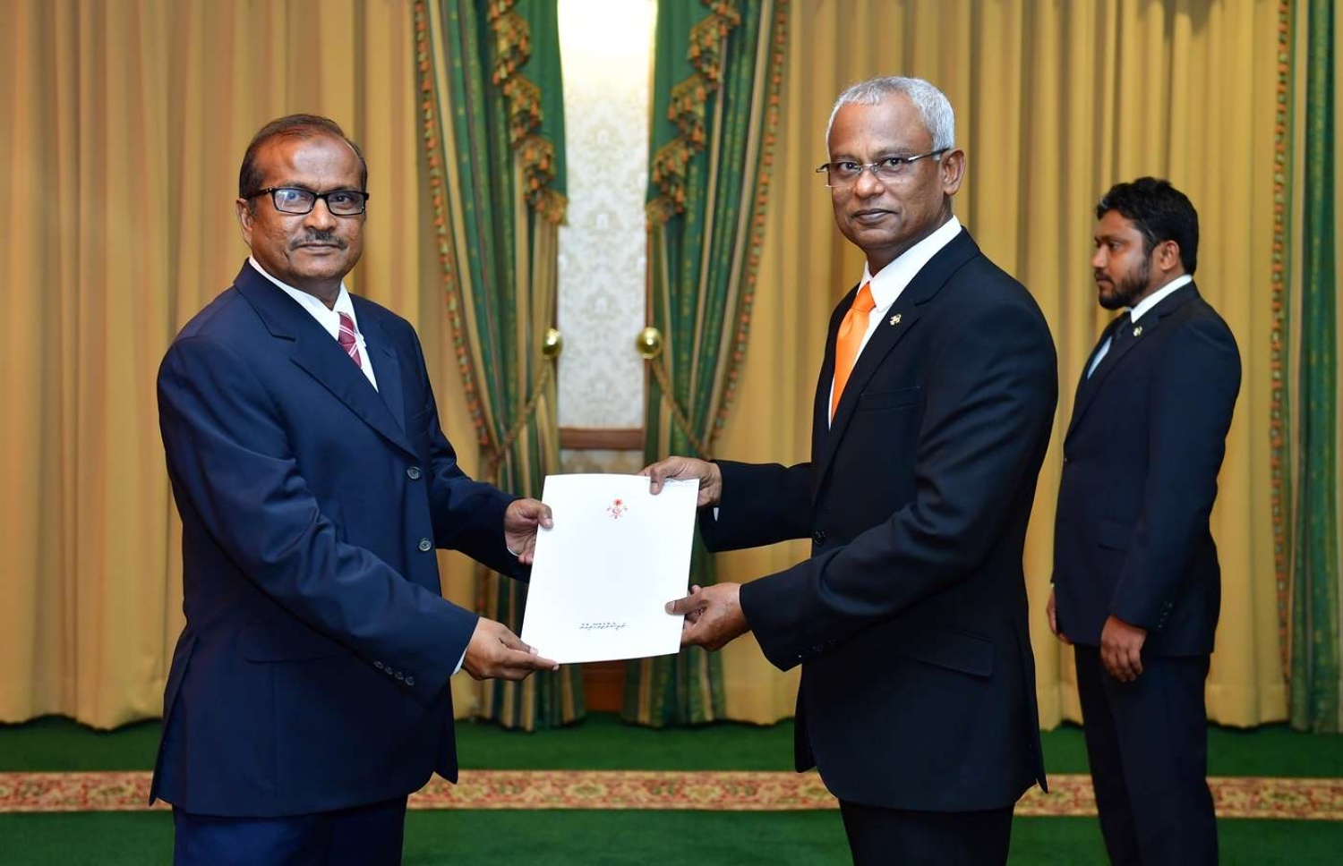 މާލެ: ނޮވެމްބަރު 28، 2018- ރައީސް އިބްރާހިމް މުހައްމަދު ސޯލިހް، ހެލްތު މިނިސްޓްރީގެ ސްޓޭޓް މިނިސްޓަރަކަށް މުހައްމަދު ޒުހައިރު އައްޔަން ކުރައްވައި އޭނާއަށް މަގާމުގެ ފަތްކޮޅު ދެއްވަނީ.---ފޮޓޯ: ރައީސް އޮފީސް