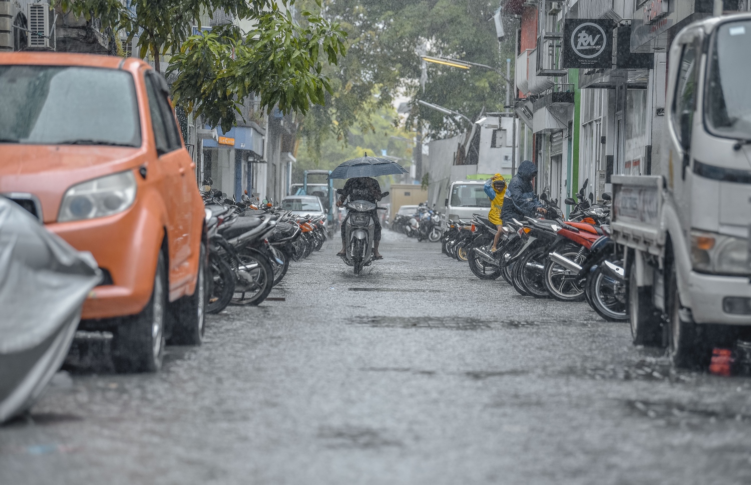 މާލެ: ނޮވެމްބަރ 29، 2018- މާލެއަށް މިއަދު ވެހުނު ބޯ ވާރޭގައި، މަގެއްގައި ފެންބޮޑުވެފައިވާއިރު މީހަކު ކުޑަ އަޅައިގެން ސައިކަލްގައި ދަނީ.---ފޮޓޯ: އަހުމަދު ނިޝާތު/މިހާރު