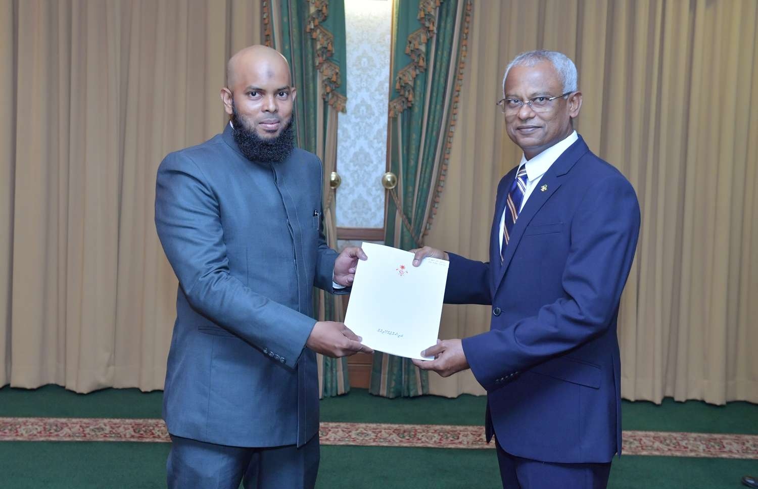 މާލެ: ނޮވެމްބަރު 29، 2018- ރައީސް އިބްރާހިމް މުހައްމަދު ސޯލިހް، އިސްލާމިކް މިނިސްޓްރީގެ ސްޓޭޓް މިނިސްޓަރުކަމަށް އިލްޔާސް ޖަމާލް އައްޔަން ކުރައްވައި އޭނާ އަށް މަގާމުގެ ފަތްކޮޅު ދެއްވަނީ.---ފޮޓޯ: ރައީސް އޮފީސް