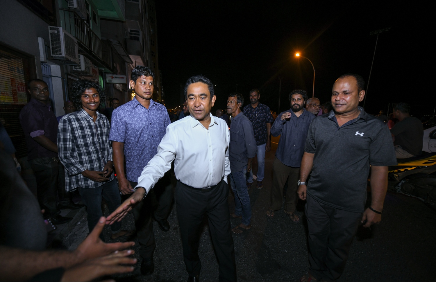 ކުރީގެ ރައީސް ޔާމީން ރޭގެ ބައްދަލުވުމަށް ފަހު ގެއަށް ވަޑައިގަންނަވަމުން މަގުމަތީގައި ތިބި ބައެއް ސަޕޯޓަރުންނާ ސަލާމް ކުރައްވަނީ.---ފޮޓޯ: ހުސައިން ވަހީދު/މިހާރު