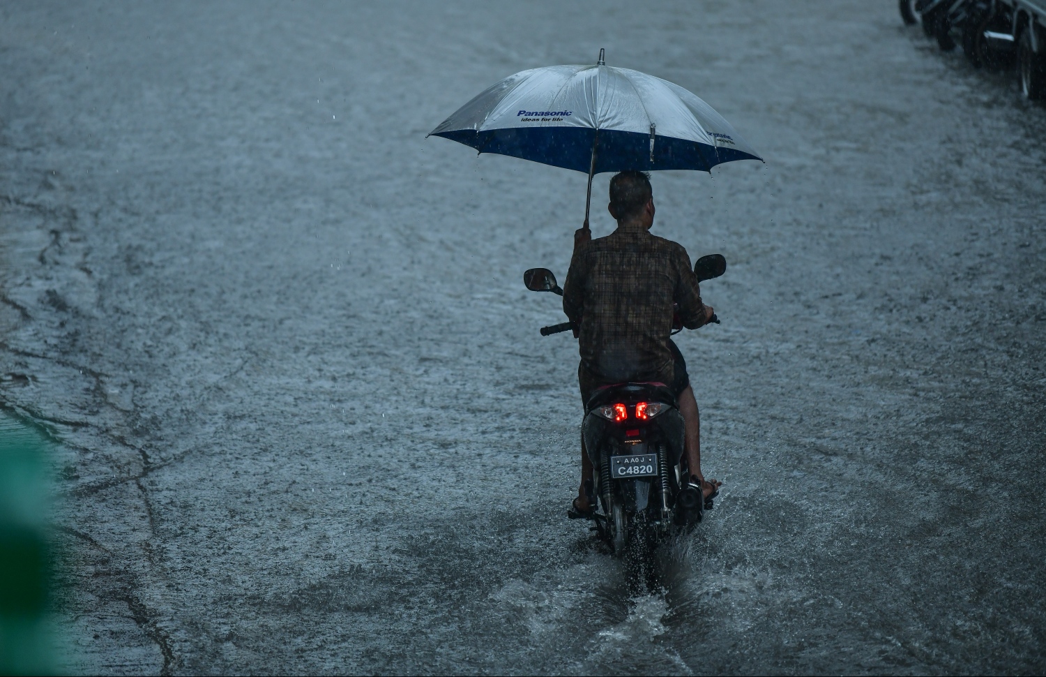 މާލެ: ޑިސެމްބަރު 5، 2018: މާލޭގައި ފެން ބޮޑުވެފައިވާ މަގަކުން މީހަކު ސައިކަލު ދުއްވާފައި ދަނީ.---ފޮޓޯ: ހުސައިން ވަހީދު/މިހާރު