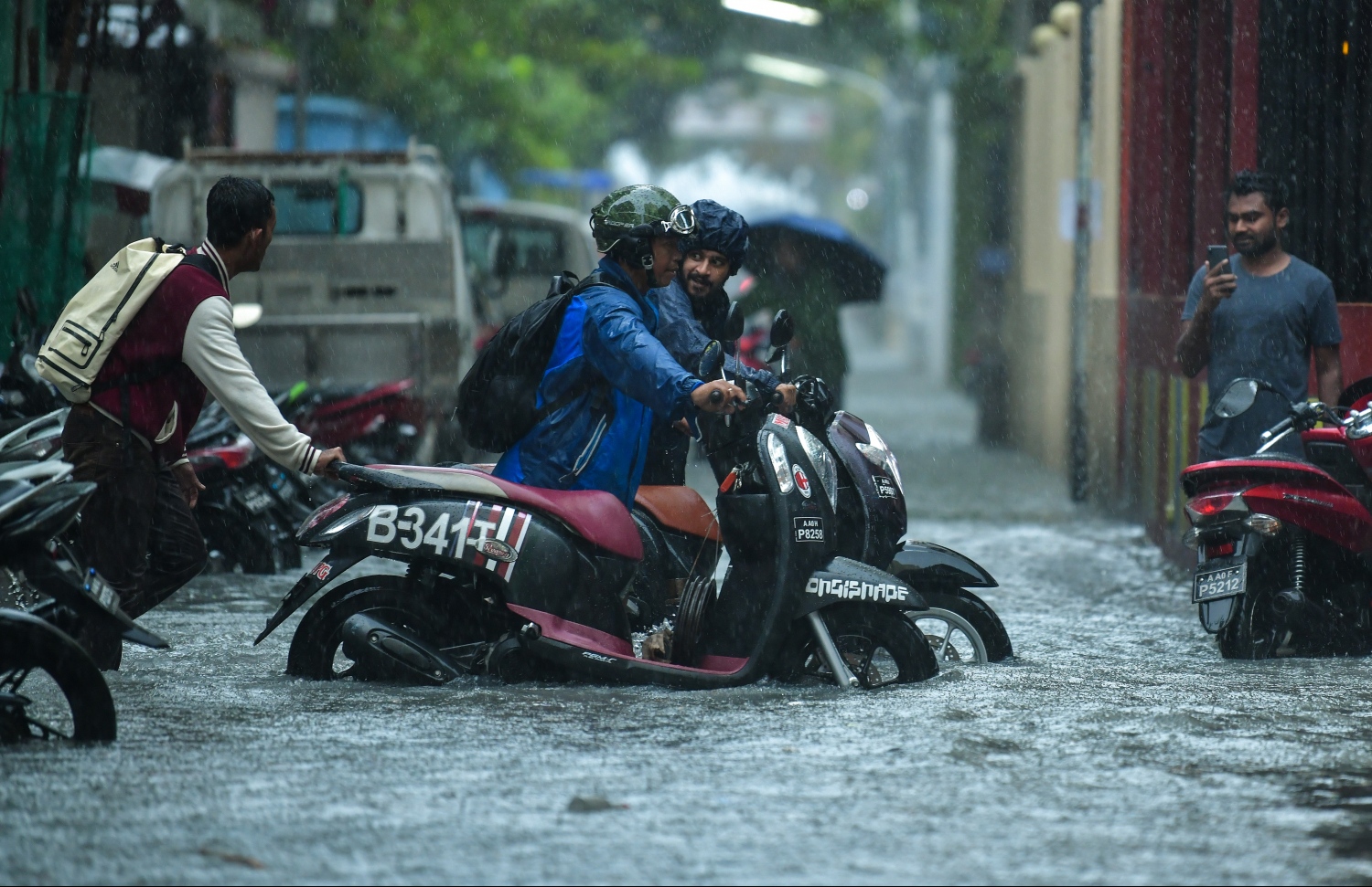 މާލެ: ޑިސެމްބަރު 5، 2018: މާލޭގައި ފެން ބޮޑުވެފައިވާ މަގަކުން ބަޔަކު ފެންގަނޑު ތެރޭގައި ސައިކަލު ކޮއްޕާފައި ދަނީ.---ފޮޓޯ: ހުސައިން ވަހީދު/މިހާރު