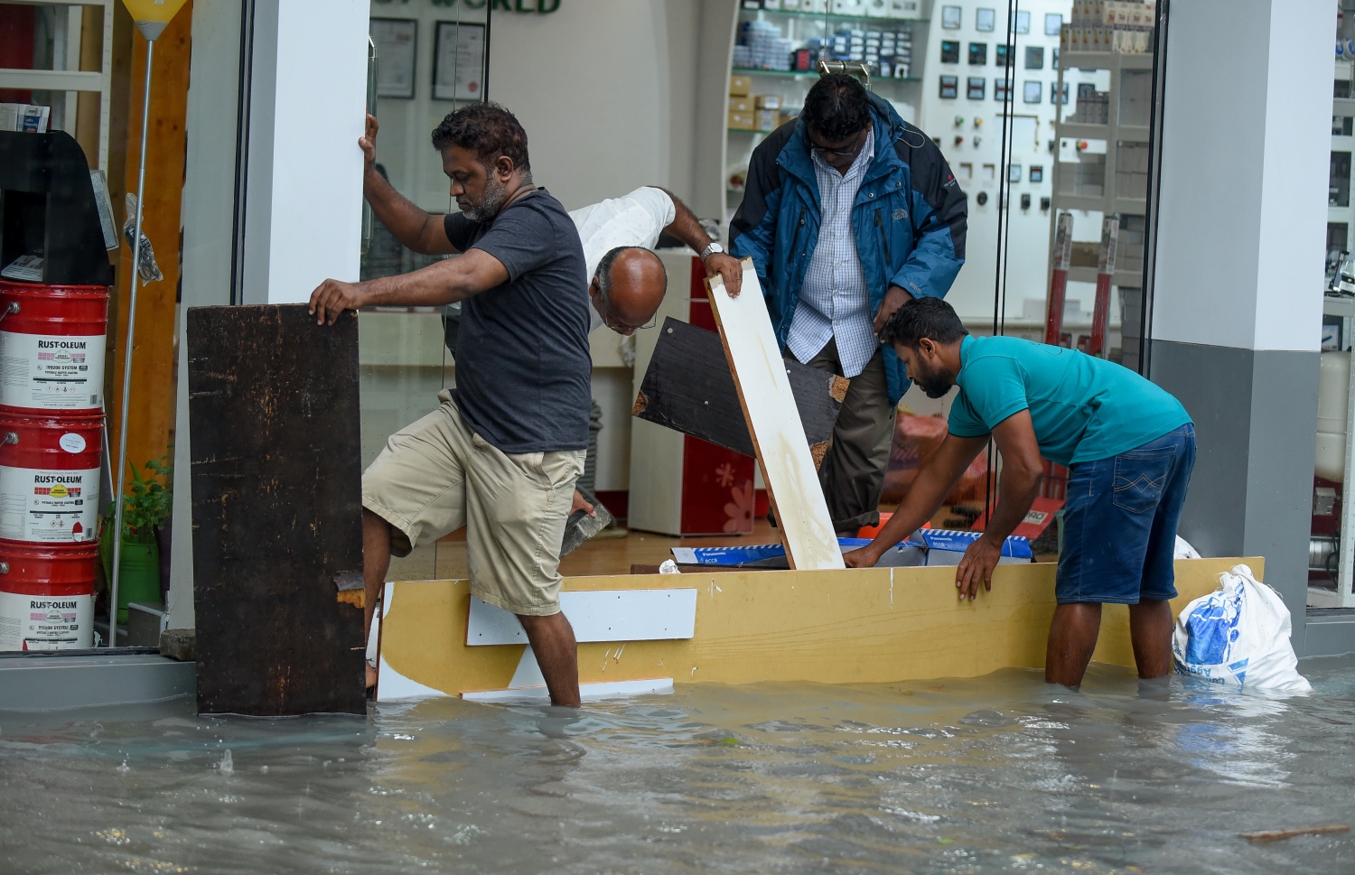 އަމީނީ މަގުގަައި ފެންބޮޑުވެ، ފިހާރައެއް ފެނުން ރައްކާ ކުރުމަށް މަސައްކަތް ކުރަނީ | ފޮޓޯ: އަހުމަދު ނީޝާތު