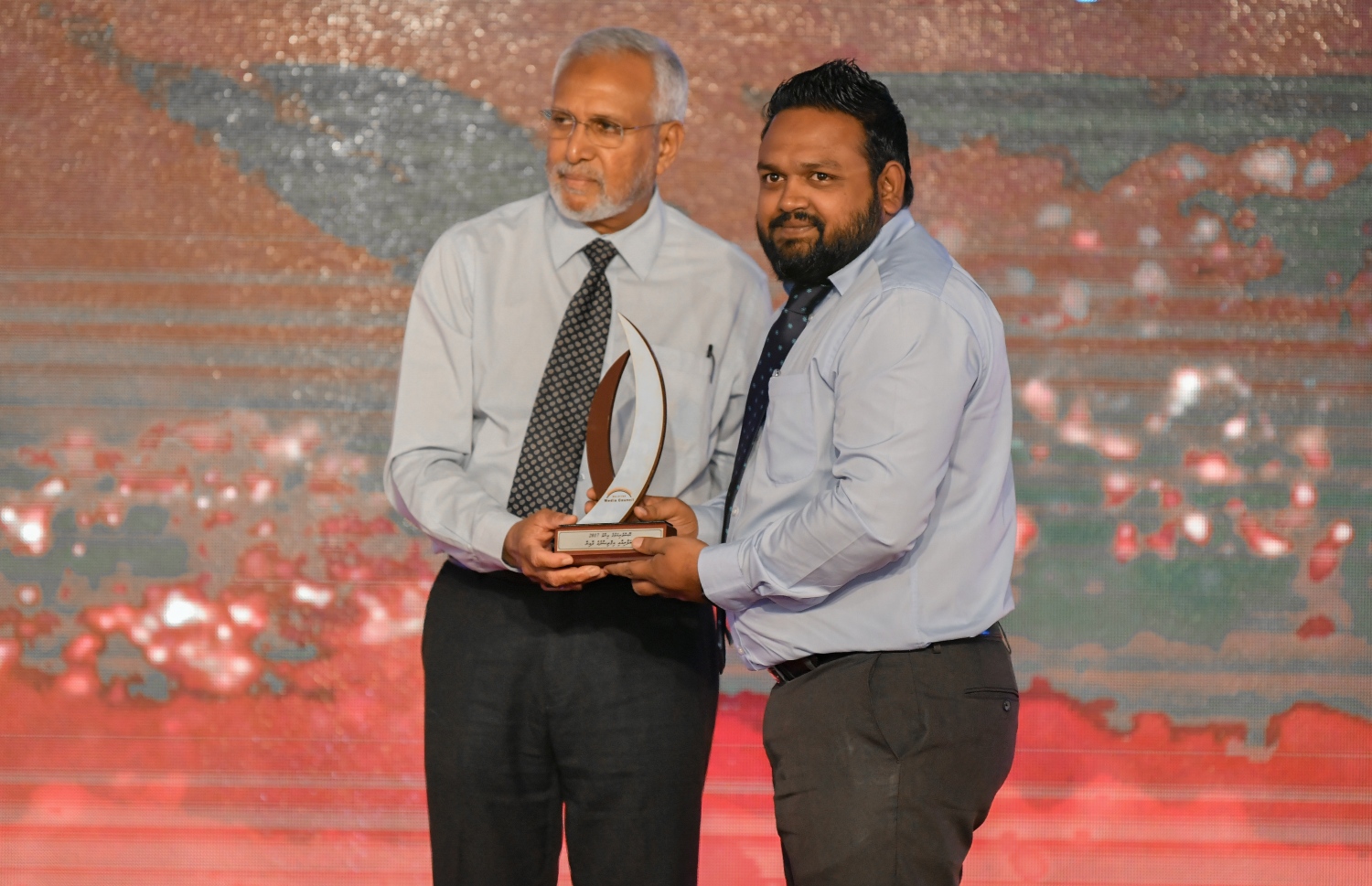 މާލެ: ޑިސެމްބަރު 5، 2018: ރާއްޖޭގެ ނޫސްވެރިކަމަށް 75 އަހަރު ފުރުމުގެ އަލިމަސްޔޫބީލް ފާހަގަ ކުރުމަށާއި ނޫސްވެރިކަމުގެ މިދިޔަ އަހަރުގެ އިނާމުތައް ދިނުމަށް މޯލްޑިވްސް މީޑިއާ ކައުންސިލާއި ހޯމް މިނިސްޓްރީ ގުޅިގެން ބޭއްވި ޖަލްސާގައި ވިޔަފާރީގެ ދާއިރާއިން ނޫސްވެރިކަމުގެ އިނާމް ހާސިލްކުރި "މިހާރު"ގެ އަބްދުﷲ ޖަމީލްއަށް އެވޯޑު ދެއްވަނީ.---ފޮޓޯ: އަހުމަދު ނިޝާތު/މިހާރު