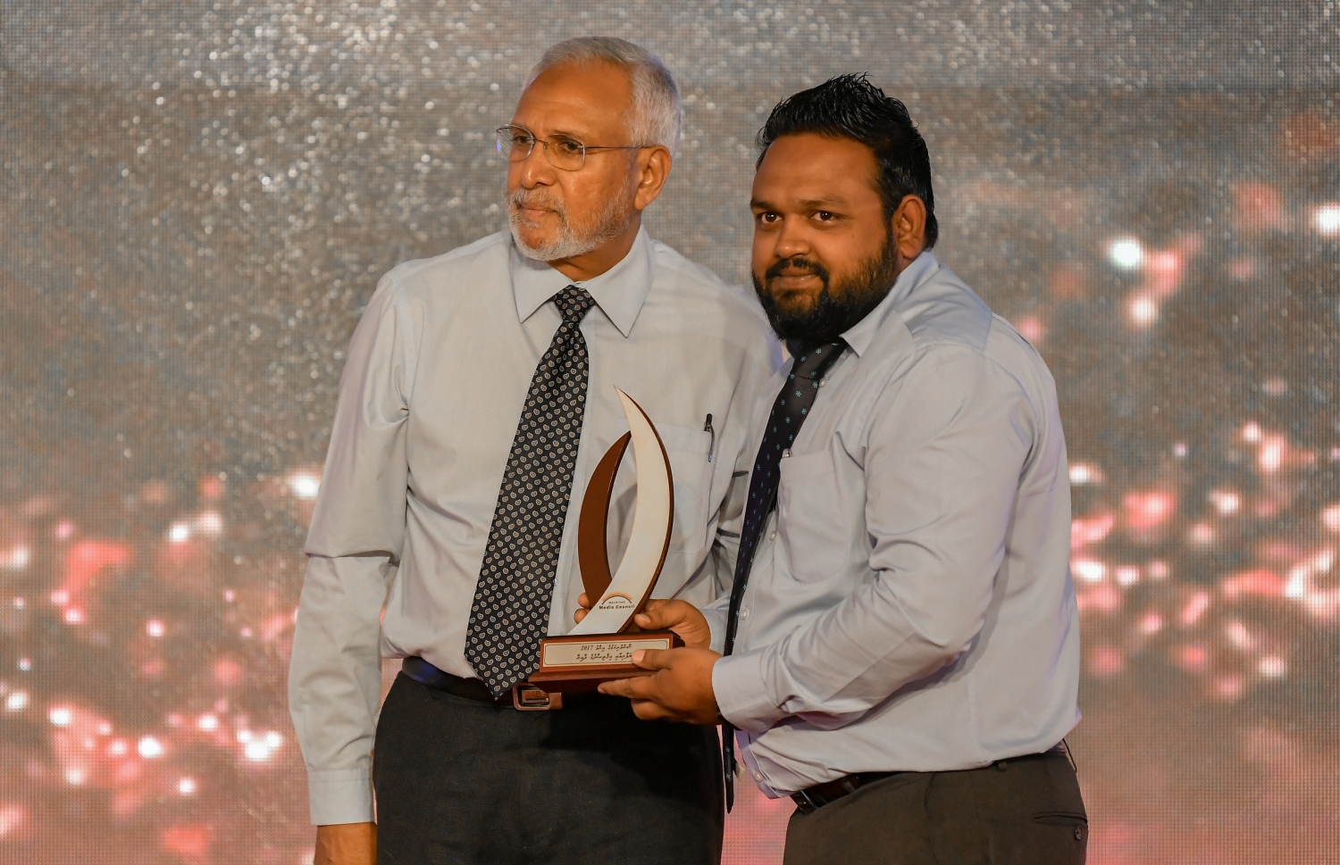 މާލެ: ޑިސެމްބަރު 5، 2018: ރާއްޖޭގެ ނޫސްވެރިކަމަށް 75 އަހަރު ފުރުމުގެ އަލިމަސްޔޫބީލް ފާހަގަ ކުރުމަށާއި ނޫސްވެރިކަމުގެ މިދިޔަ އަހަރުގެ އިނާމުތައް ދިނުމަށް މޯލްޑިވްސް މީޑިއާ ކައުންސިލާއި ހޯމް މިނިސްޓްރީ ގުޅިގެން ބޭއްވި ޖަލްސާގައި ނޫސްވެރިކަމުގެ އިނާމް ހާސިލްކުރި 2 ނޫސްވެރިން ކަމަށްވާ 'މީހާރު" އޮންލައިން ގެ މުއިއްޒު އިބްރާހީމް އާއި "އަވަސް" އޮންލައިންގެ ނާޒިމް ފޮޓޯއަކަށް ހުއްޓިގެން.---ފޮޓޯ: އަހުމަދު ނިޝާތު/މިހާރު