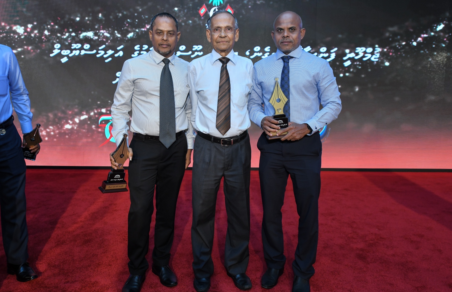 މާލެ: ޑިސެމްބަރު 11، 2018: ރާއްޖޭގެ ނޫސްވެރިކަމަށް 75 އަހަރު ފުރުމުގެ އަލިމަސްޔޫބީލް ފާހަގަ ކުރުމަށާއި ނޫސްވެރިކަމުގެ މިދިޔަ އަހަރުގެ އިނާމުތައް ދިނުމަށް މޯލްޑިވްސް މީޑިއާ ކައުންސިލާއި ހޯމް މިނިސްޓްރީ ގުޅިގެން ބޭއްވި ޖަލްސާގައި ނޫސްވެރިކަމުގެ އަލިމަސް ގަލަން ހާސިލްކުރެއްވި ޑރ. މުހައްމަދު ޒާހިރު ހުސައިން އާއެކު ރަން ގަލަން ހާސިލްކުރެއްވި "މިހާރު" ނޫހުގެ އެޑިޓަރު މޫސާ ލަތީފު އަދި ސަން އޮންލައިންގެ ޗީފް އެޑިޓަރު ހިރިގާ އަހުމަދު ޒާހިރު ފޮޓޯއަކަށް ހުއްޓިގެން.---ފޮޓޯ: އަހުމަދު ނިޝާތު/މިހާރު