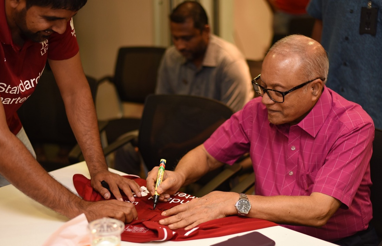 ސަޕޯޓަރެއްގެ ޖާޒީގައި މައުމޫން ސޮއިކުރައްވަނީ.