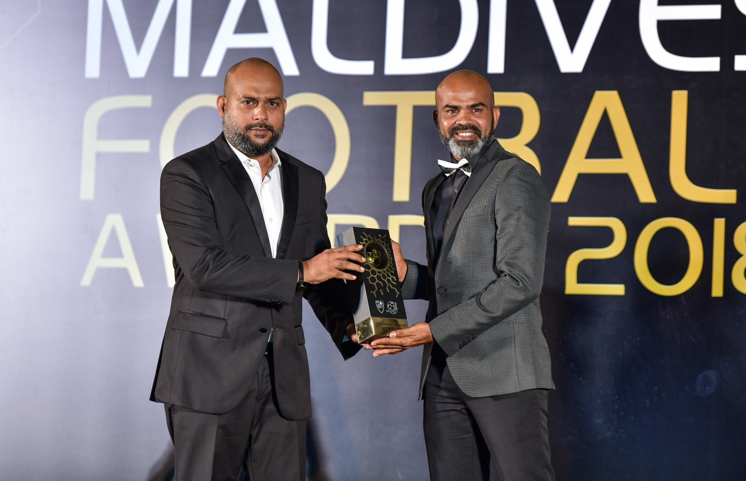 އޮލިމްޕިކް ކޮމިޓީގެ ރައީސް ޝަވީދު (މ) އެންމެ މޮޅު ކޯޗަކަށް ހޮވުނު ނިޒާމްބެއާ އެވޯޑް ހަވާލުކުރަނީ. -- ފޮޓޯ: ނިޝާން އަލީ/ މިހާރު