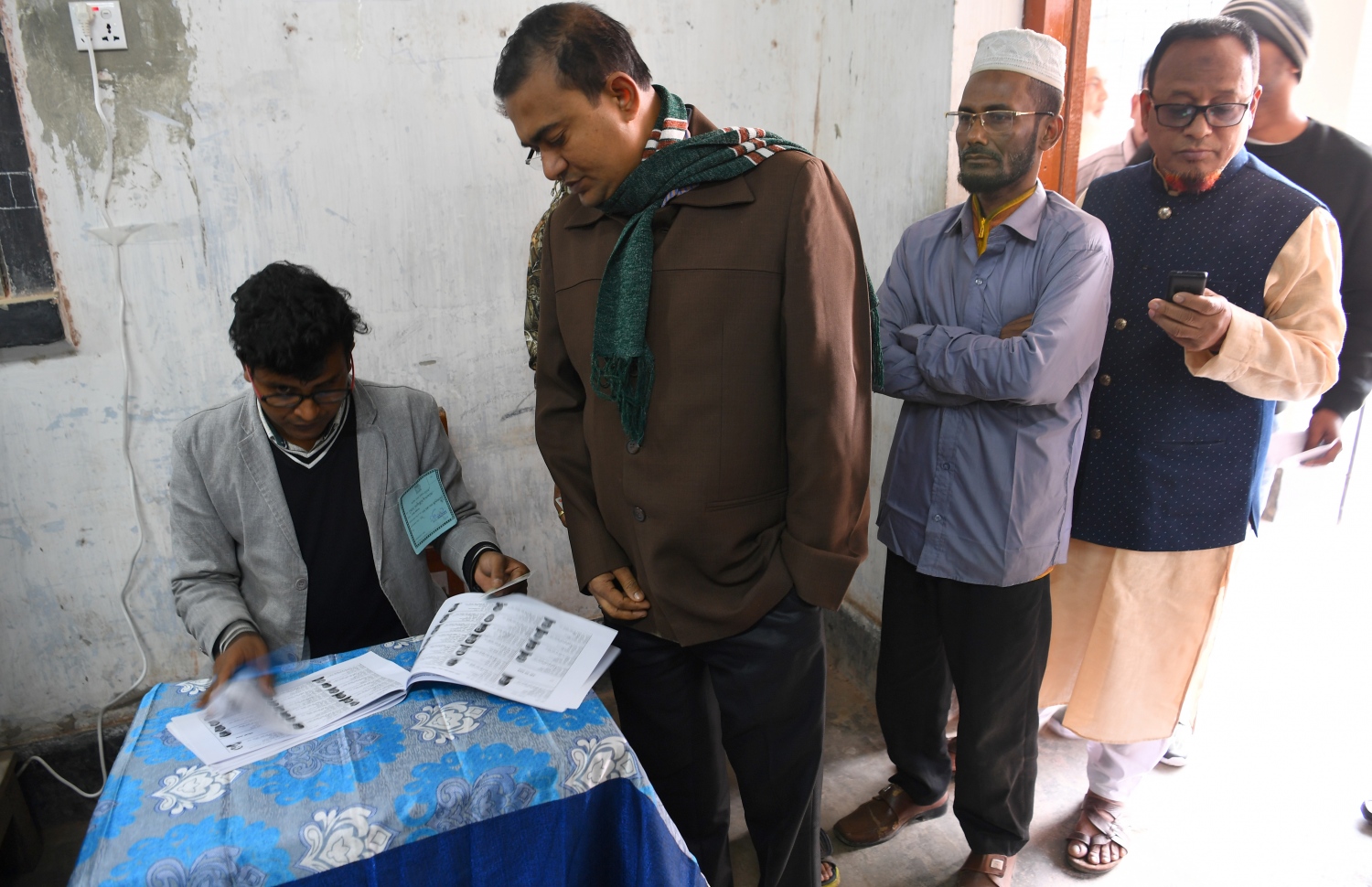 ބަންގްލަދޭޝްގެ އިންތިޚާބުގައި ވޯޓުލާ މީހުންގެ ނަން ޗެކް ކުރަނީ. --ފޮޓޯ:އޭއެފްޕީ