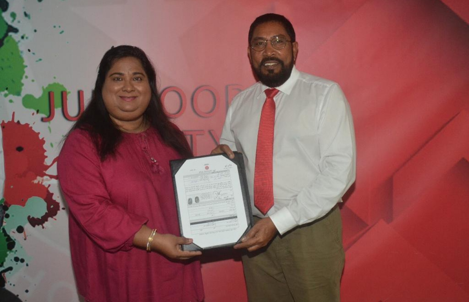 ޑރ. އާމަލް ޖޭޕީއަށް ސޮއިކުރެއްވުމަށް ފަހު ގާސިމާ ފޯމު ހަވާލުކުރައްވަނީ .- ފޮޓޯ: ޖޭޕީ