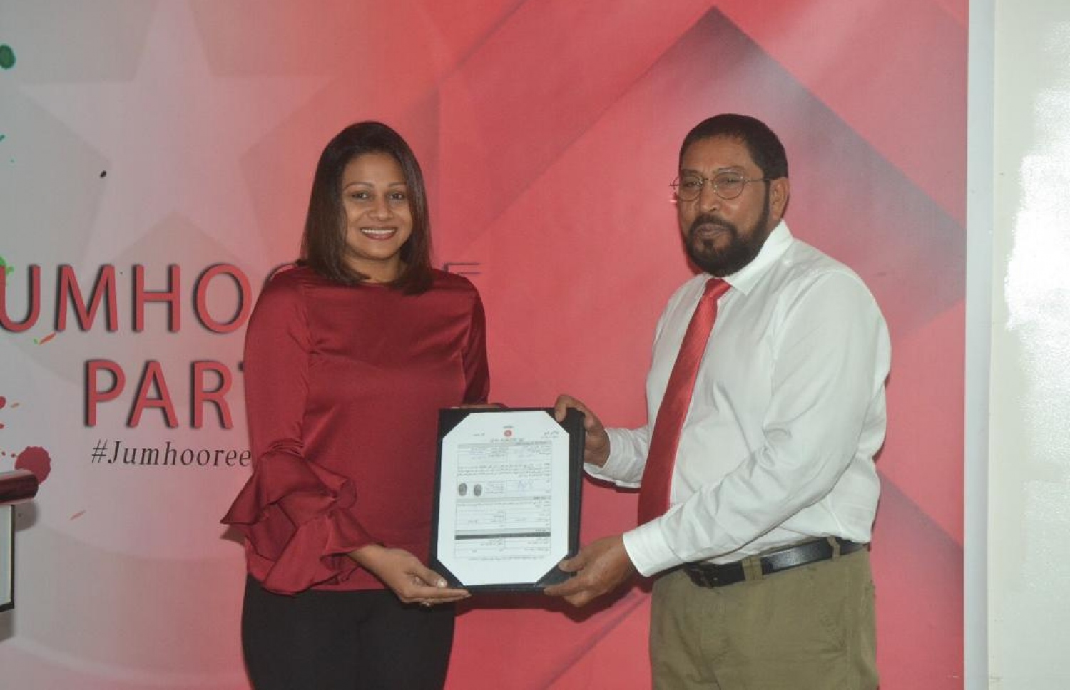 އެފްއޭއެމްގެ ނައިބު ރައީސް ނާޒިމާ ޖޭޕީއަށް ސޮއިކުރެއްވުމަށް ފަހު، ޕާޓީގެ ލީޑަރު ގާސިމާ ފޯމު ހަވާލުކުރައްވަނީ -- ފޮޓޯ: ޖޭޕީ