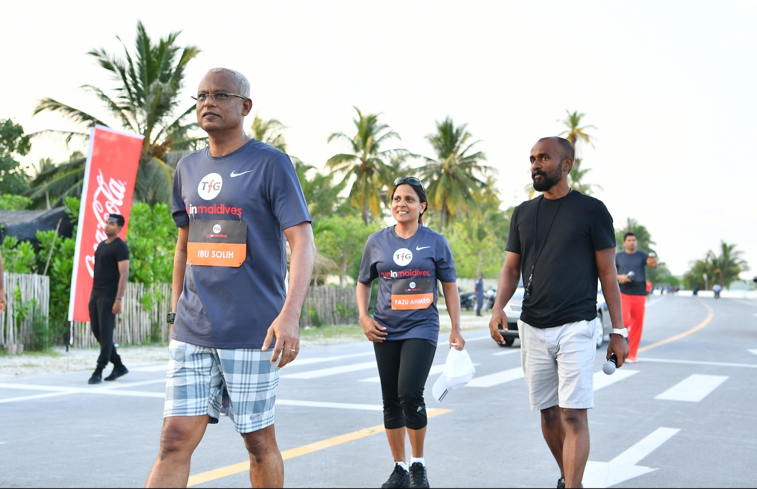 ލ.ގަން: ޖެނުއަރީ 26، 2019- ޓޯޓަލް ފިޓްނަސް ގްރޫޕް (ޓީއެފްޖީ) އިން ލ. އަތޮޅުގައި ބާއްވާ "ކޮކާ ކޯލާ ރަން އިން ލާމު"ގެ ފަސް ކިލޯމީޓަރު ދުވުމުގެ ހަރަކާތުގައި ރައީސް އިބްރާހިމް މުހައްމަދު ސޯލިހު އަދި އަނބިކަނބަލުން ފަޒްނާ ބައިވެރިވެވަޑައިގަންނަވާއިރު އަރިހުގައި ޓީއެފްޖީގެ ޓެކްނިކަލް ޑައިރެކްޓަރު ޒިނާން.---ފޮޓޯ: ރައީސް އޮފީސް