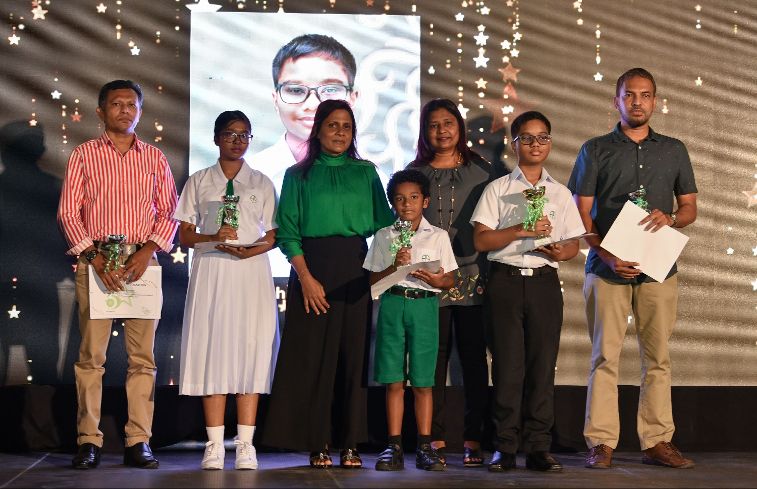 އަމީނިއްޔާ ސްކޫލަށް 75 އަހަރުފުރުމާ ގުޅޭގޮތުން ބޭއްވި ލޯގޯ ހެދުމުގެ މުބާރާތުގައި، އެންމެ މޮޅު ފަސް ލޯގޯ ހެދި ދަރިވަރުންނާއެކު ފަސްޓްލޭޑީ ފަޒްނާ ފޮޓޯއަކަށް ހުއްޓިވަޑައިގެން . --ފޮޓޯ: ހުސެއިން ވަހީދު/ މިހާރު
