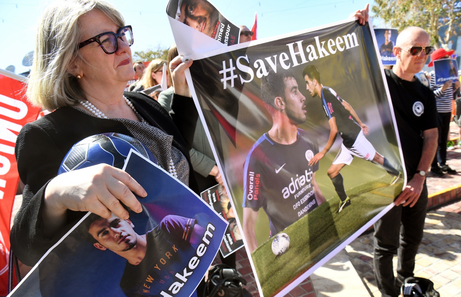 ހަކީމް ދޫކޮށްލުމަށް އެދި އޮސްޓްރޭލިއާގެ މެލްބަންގައި ކުރިއަށްދިޔަ އެއްވުމެއްގެ ބައިވެރިއަކު އޭނާގެ ޕޯސްޓަރުތަކެއް ހިފައިގެން. -- ފޮޓޯ: އޭއެފްޕީ