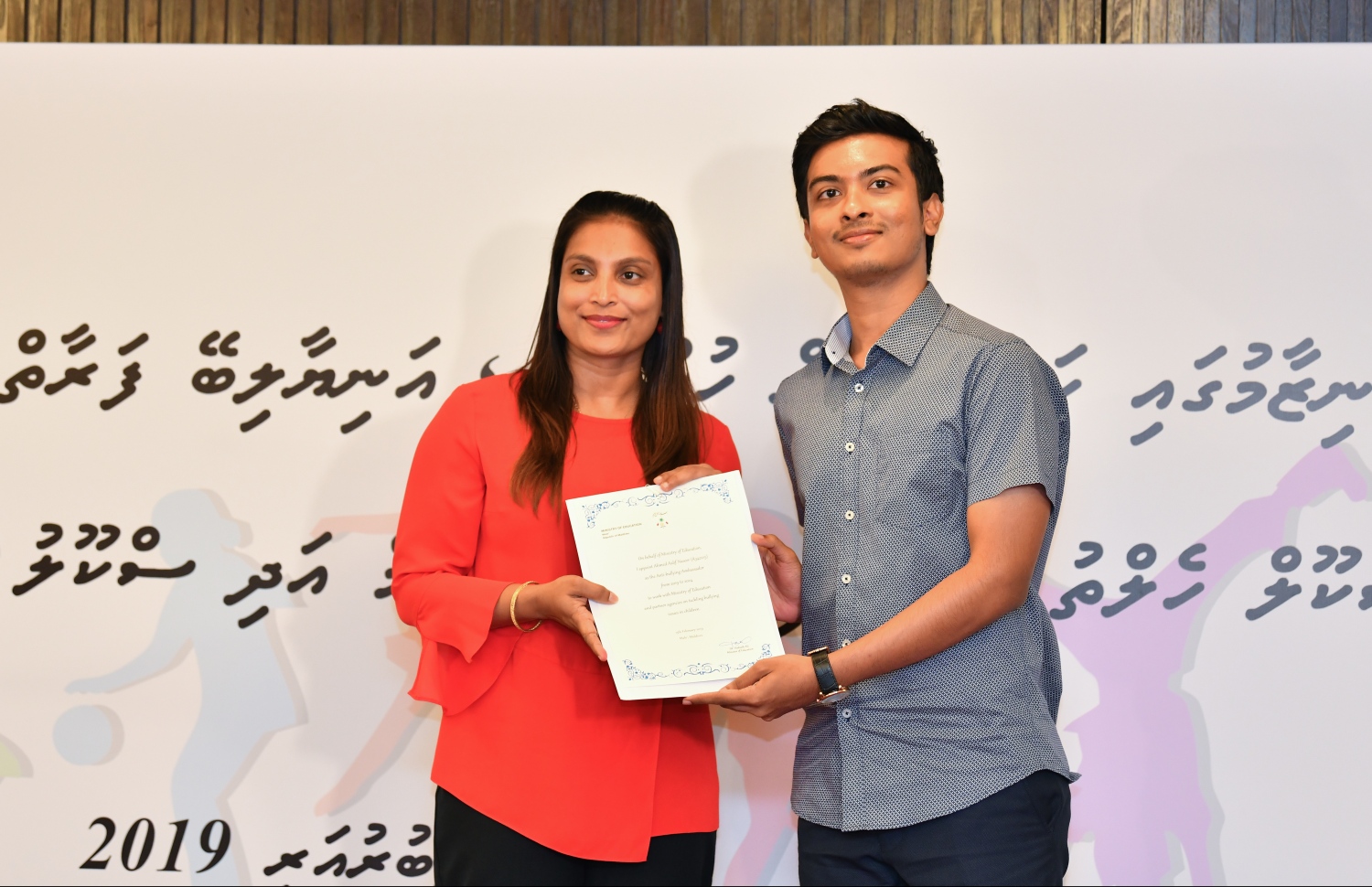 އެންޓި-ބުލީން އެމްބެސެޑަރަށް ހަމަޖެއްސި އާލް ނަސީރަށް، އެޑިއުކޭޝަން މިނިސްޓަރު ޑރ. އާއިޝަތު އަލީ ލިޔުން ހަވާލުކޮށްދެއްވަނީ.-- ފޮޓޯ: ހުސެއިން ވަހީދު/ މިހާރު